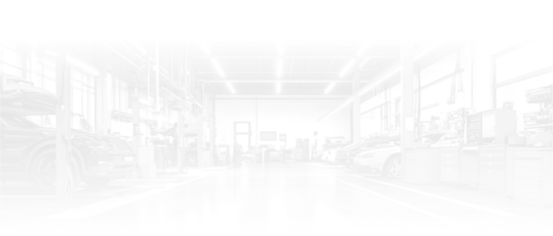 Interior of a bright, white industrial space with windows and lights.