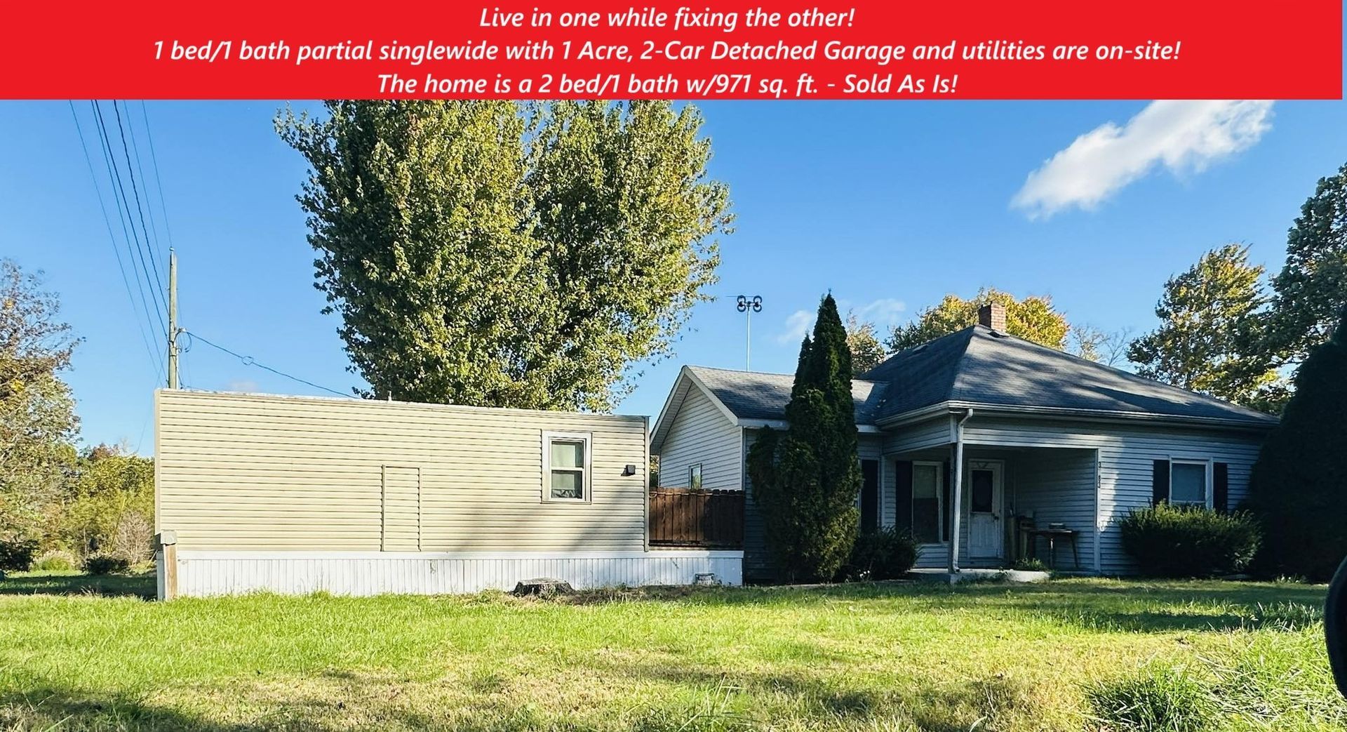 House with attached storage and trees. Green grass. 