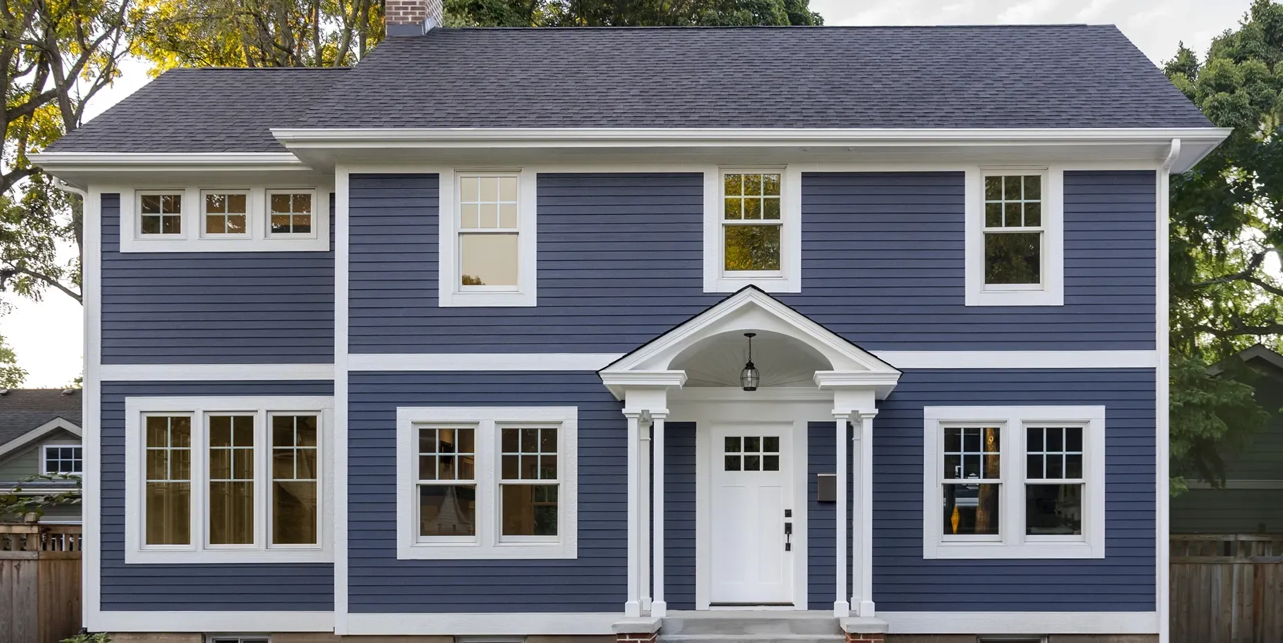 A large blue house with white trim and windows