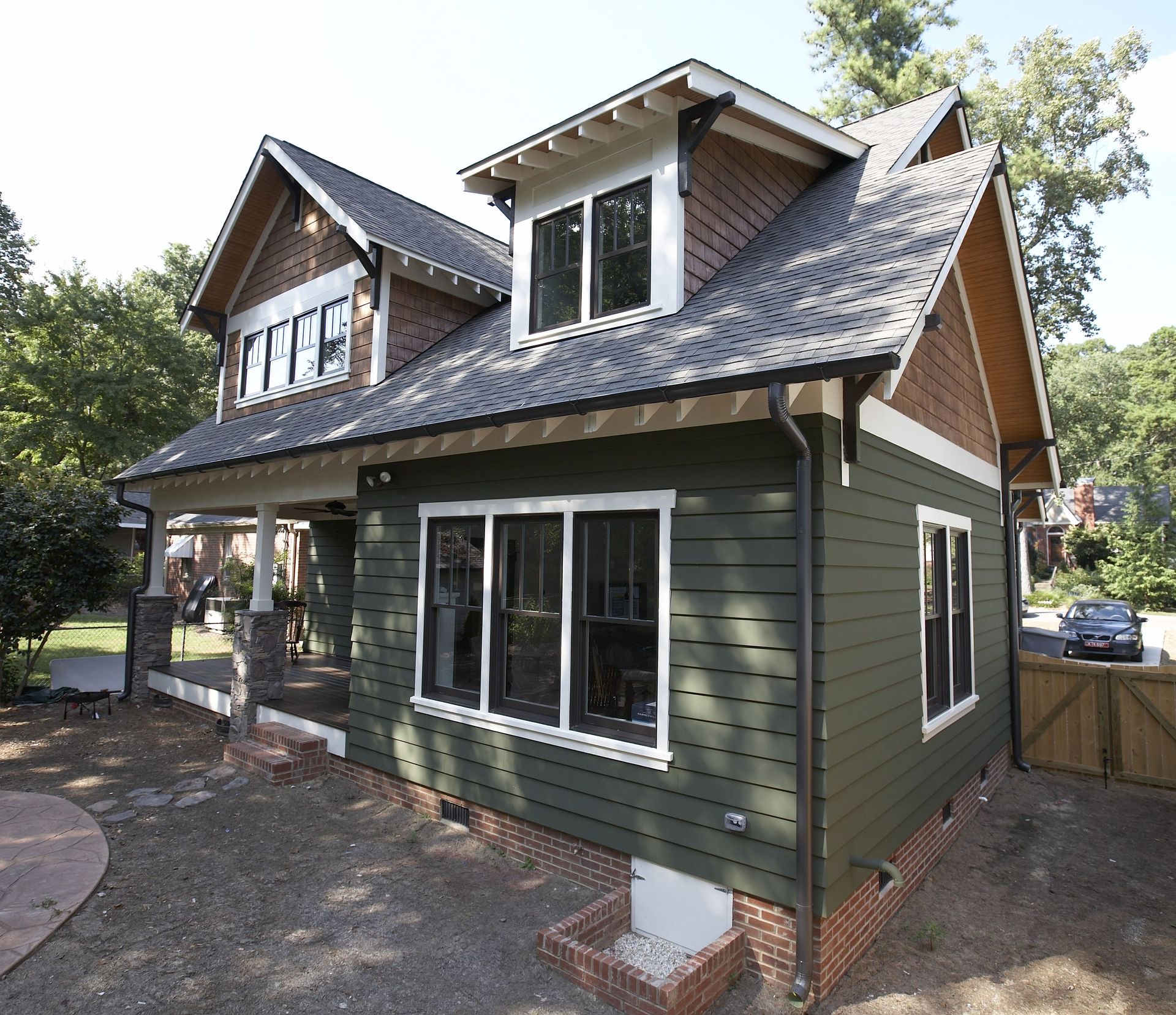 A green house with a roof that has shingles on it
