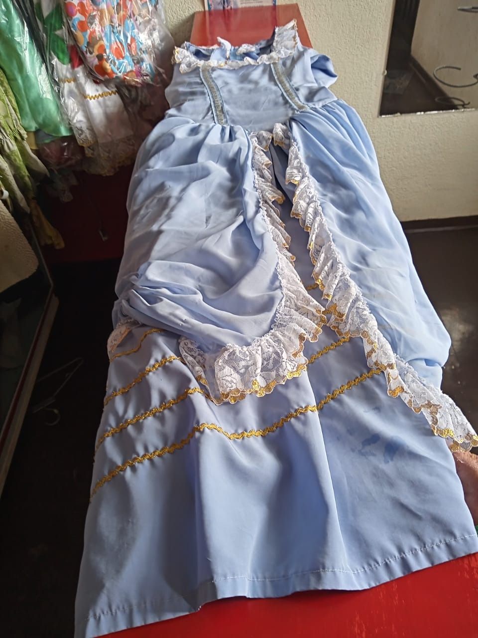 Un vestido azul yace sobre una mesa roja.