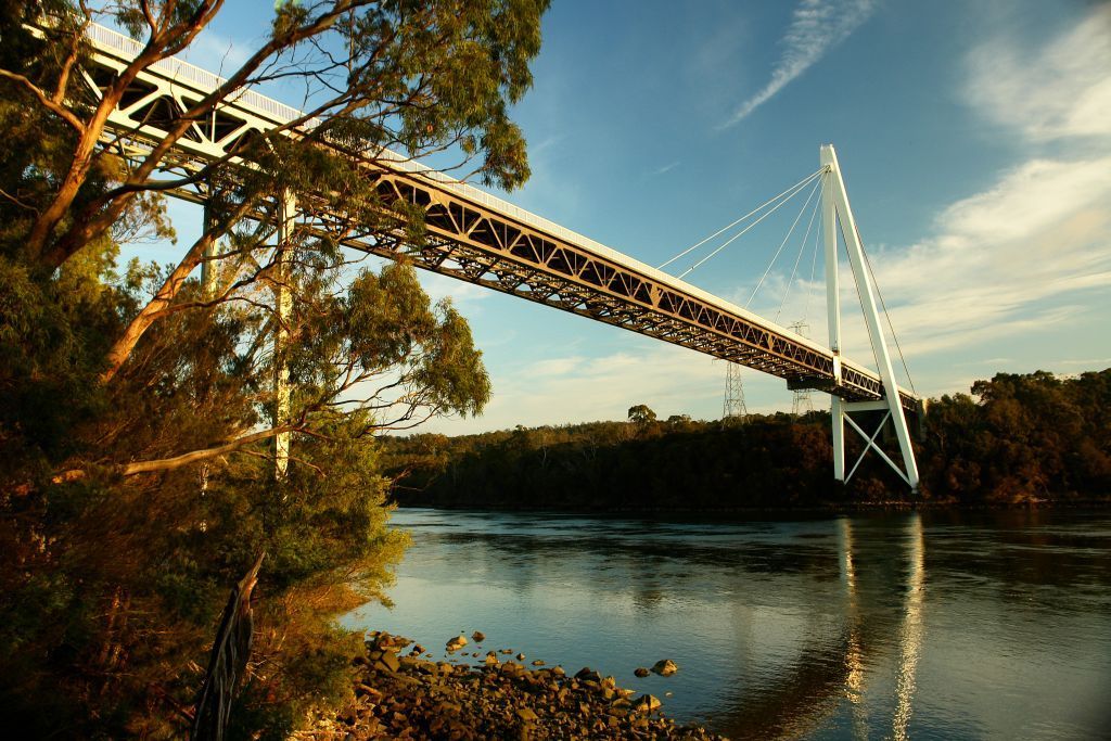 A bridge over a river with trees in the background