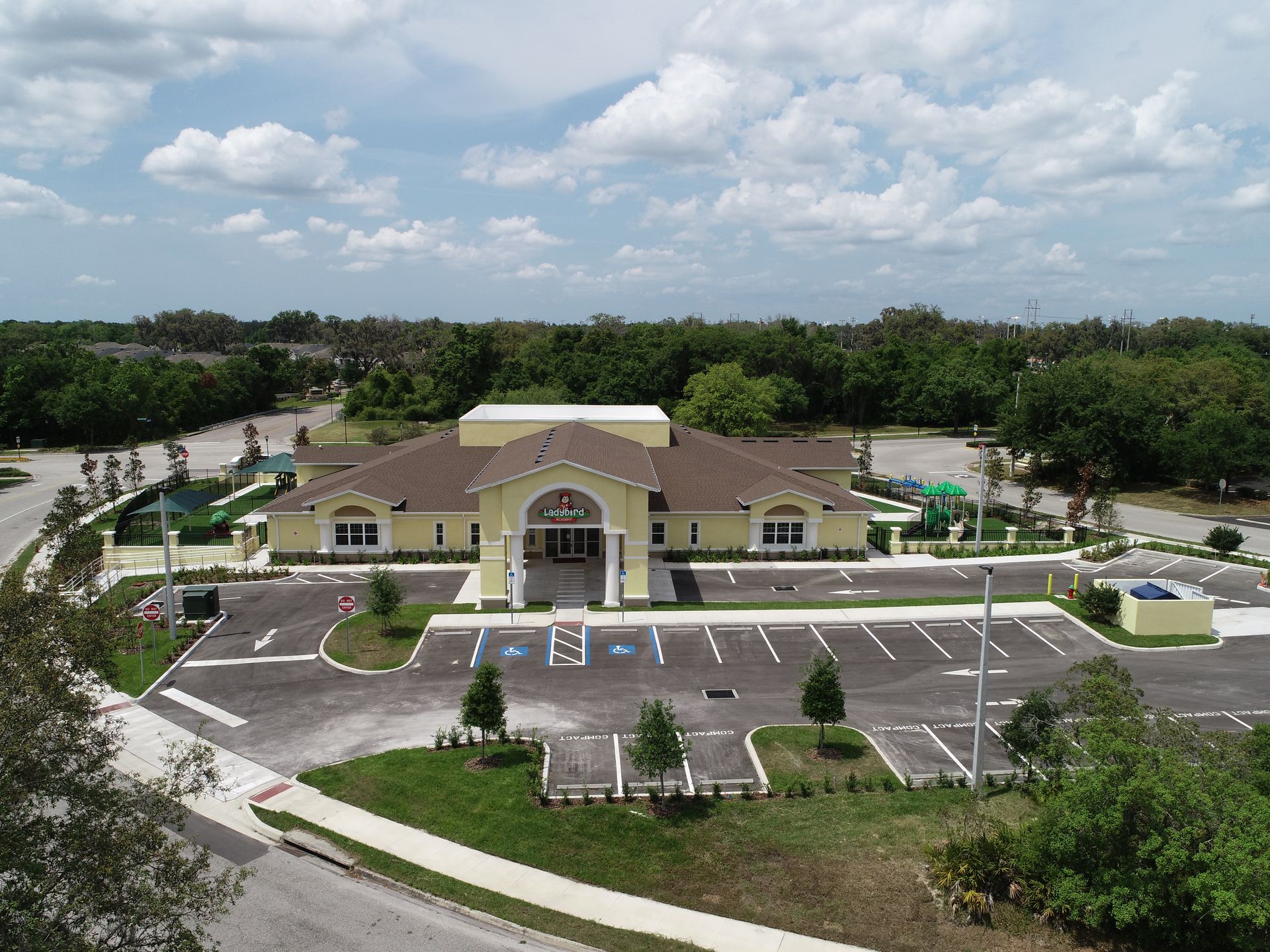An aerial view of a large building with a parking lot in front of it.