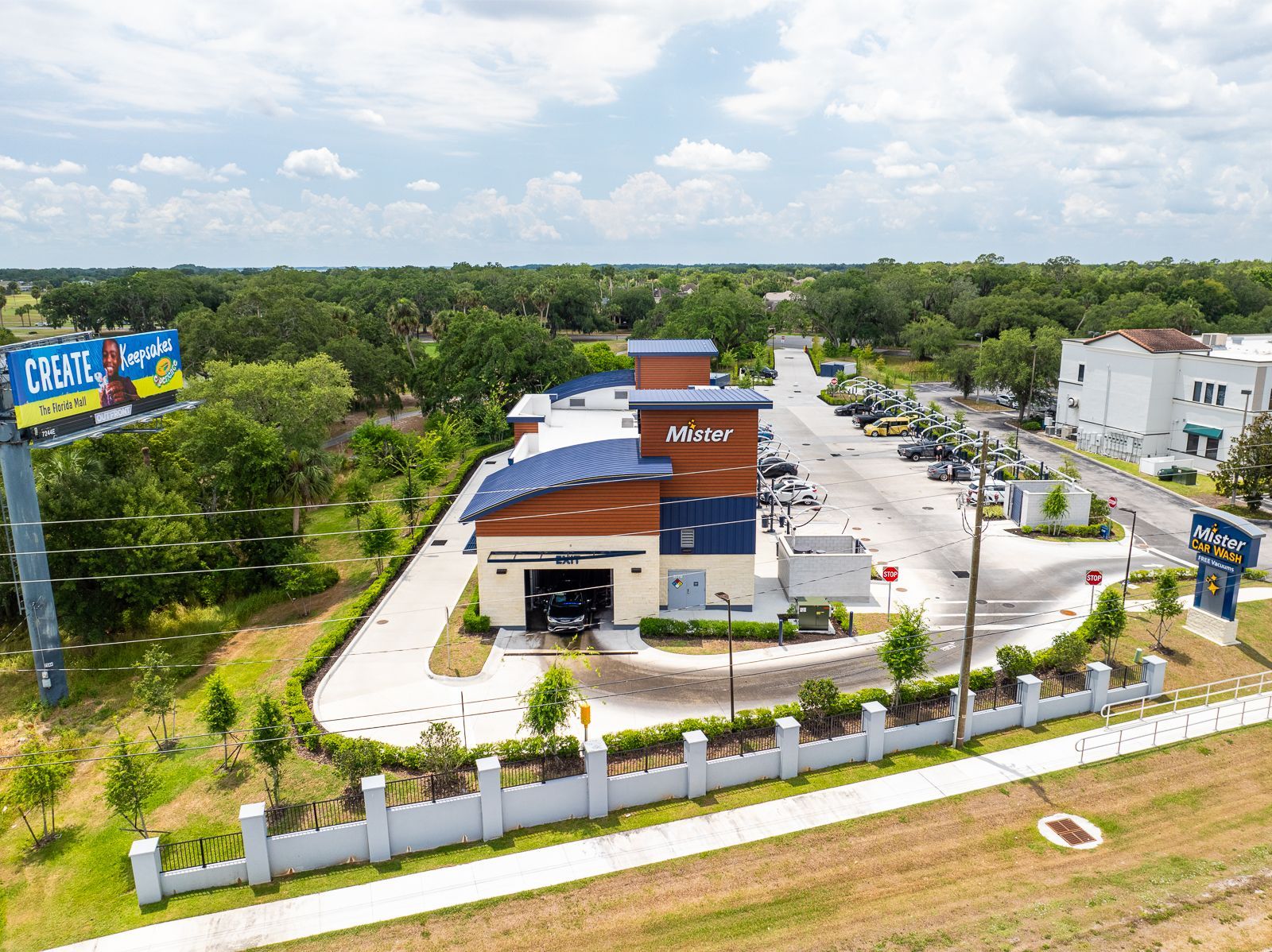 An aerial view of a car wash with a billboard in the background.