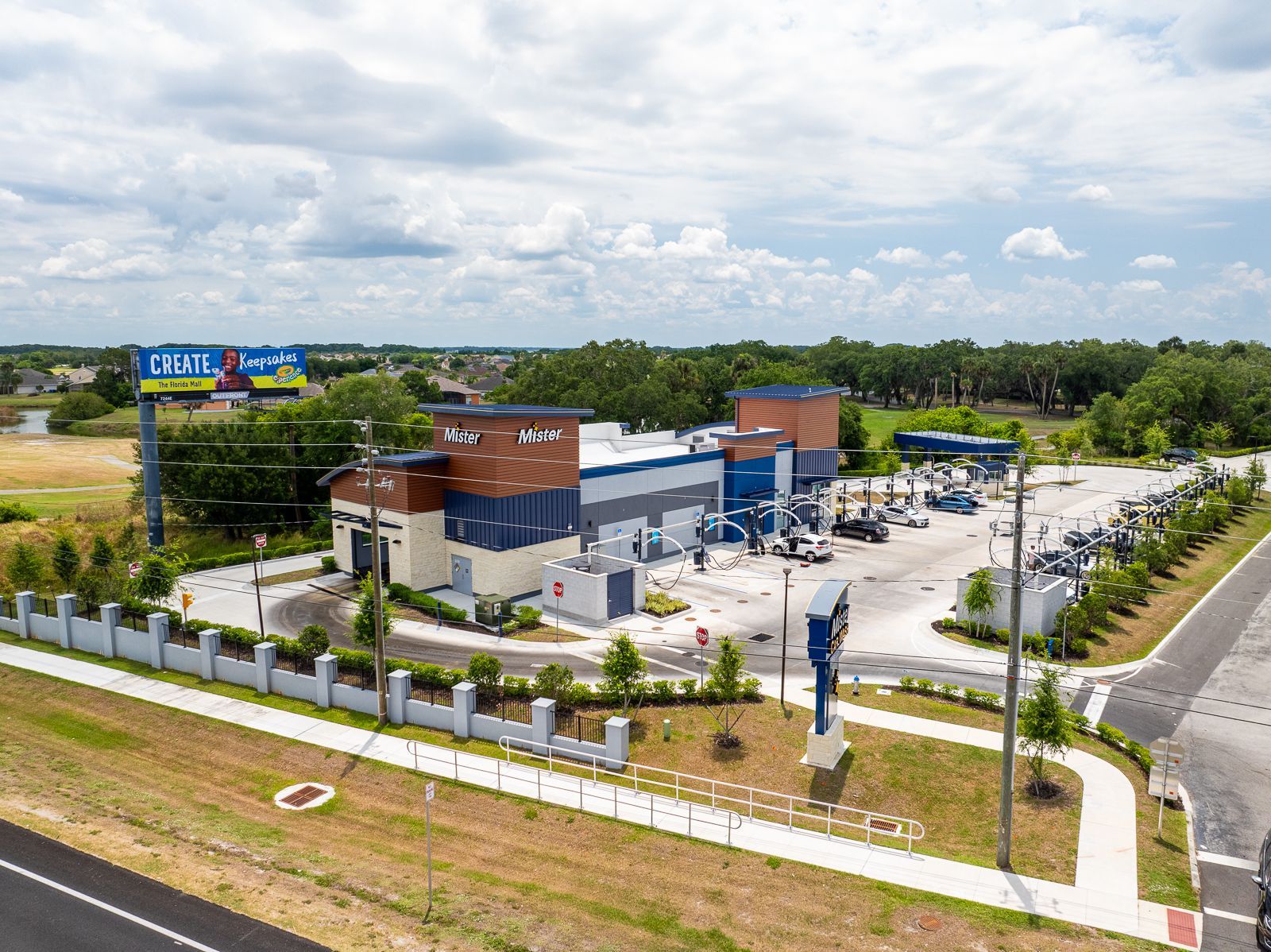 An aerial view of a car wash with a lot of cars parked in front of it.