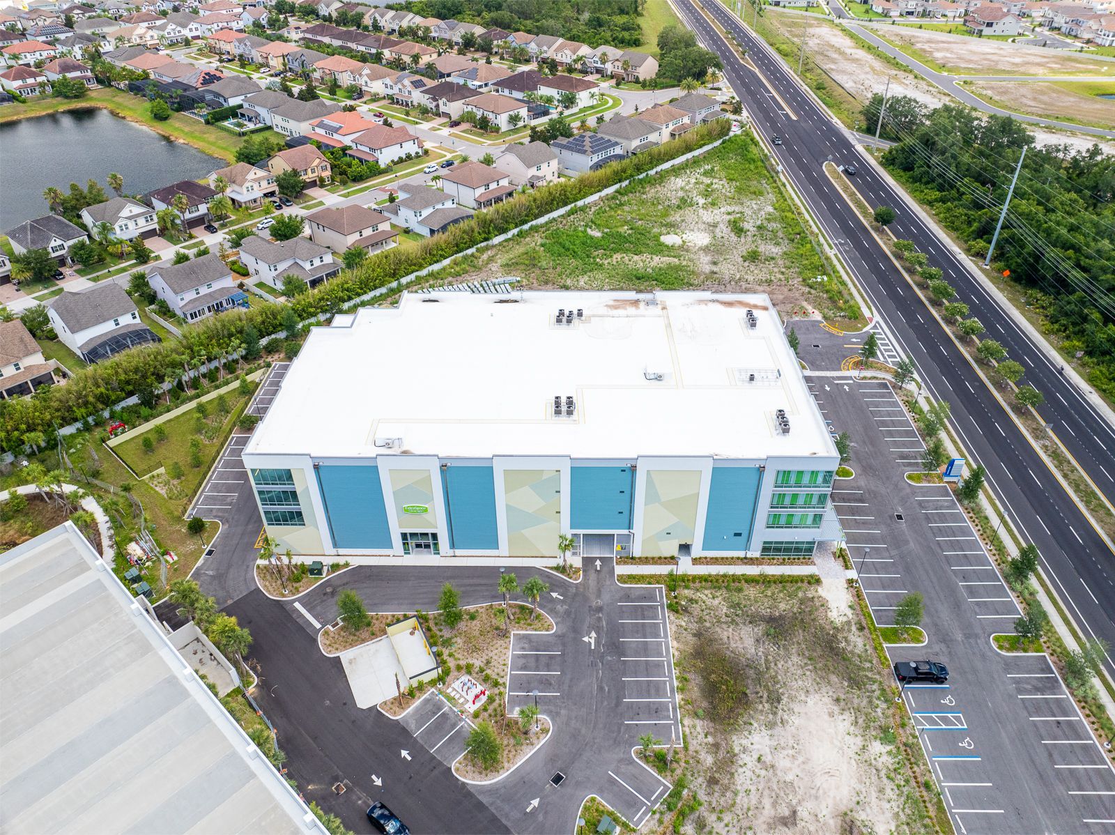 An aerial view of a large building with a parking lot in front of it.