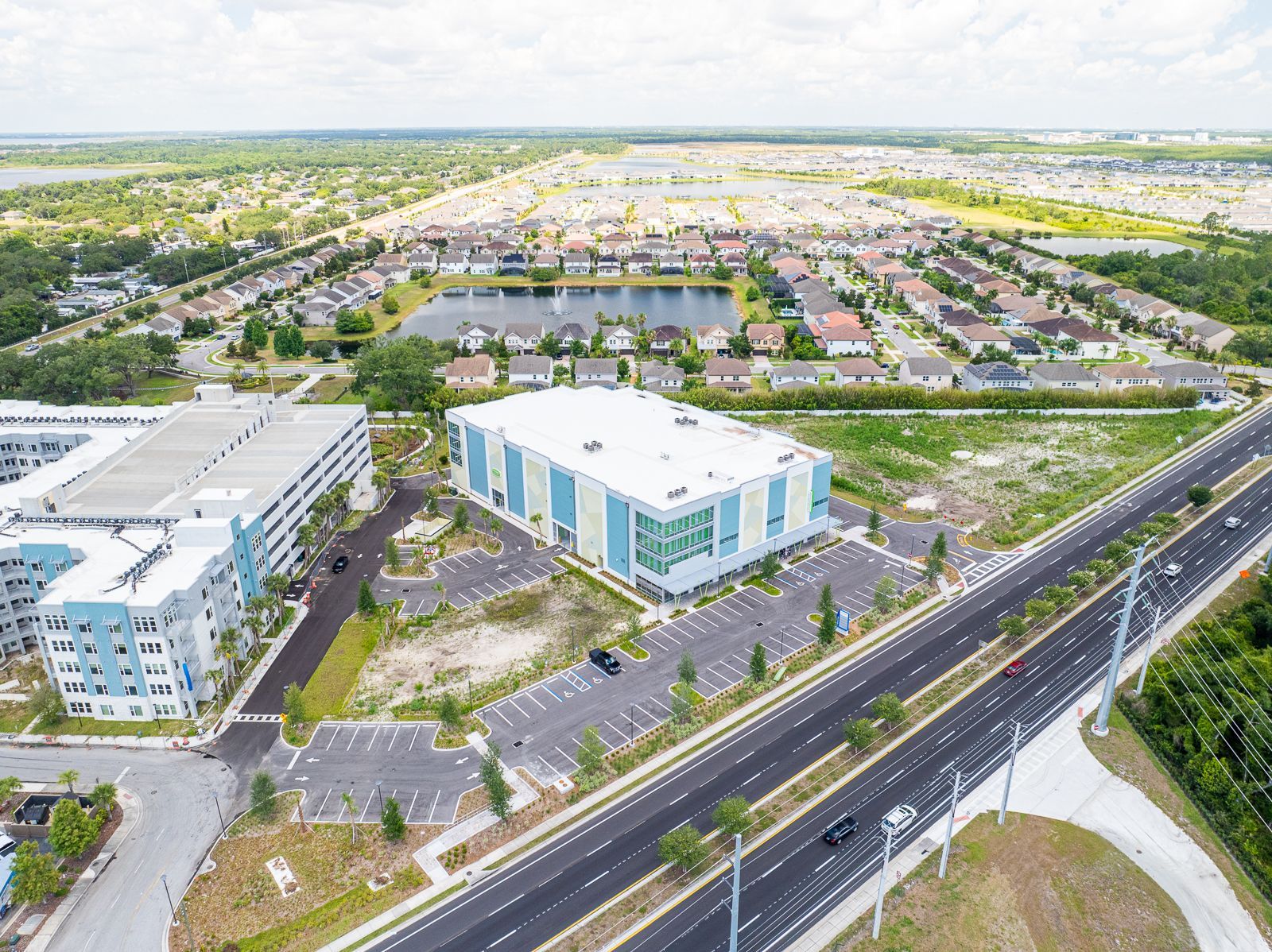 An aerial view of a large building next to a highway.