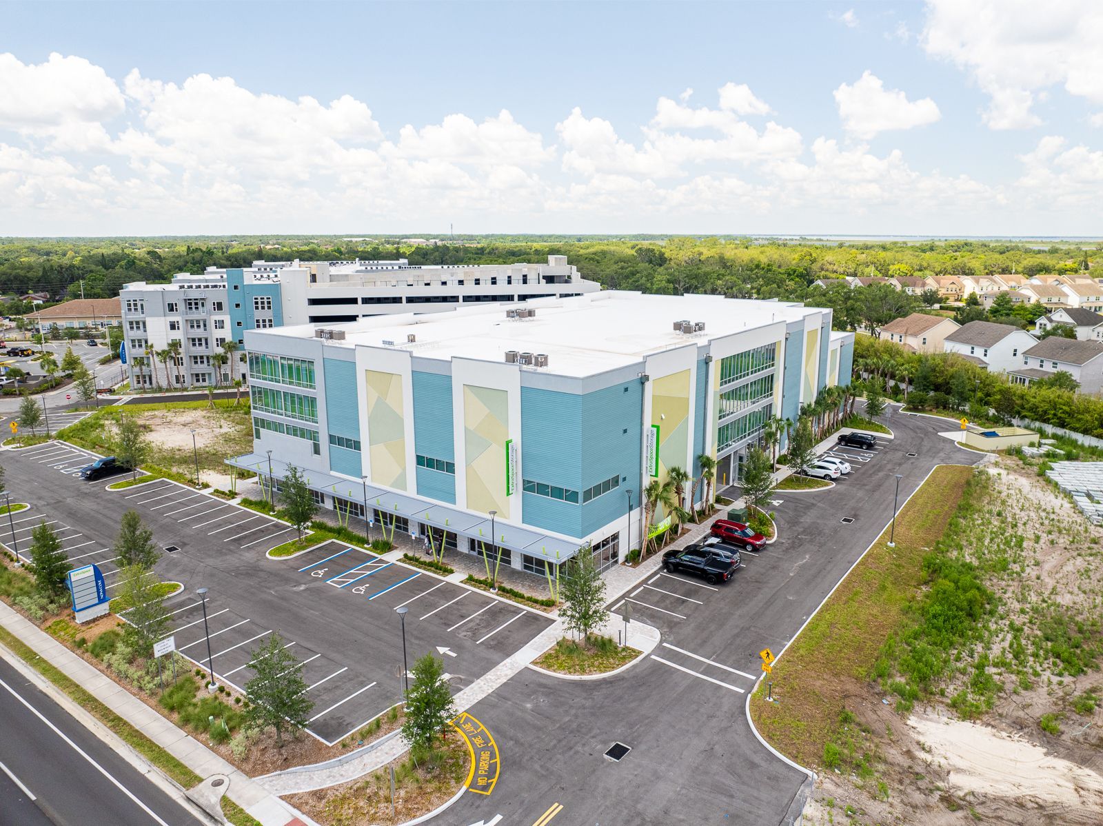 An aerial view of a large building with a parking lot in front of it.