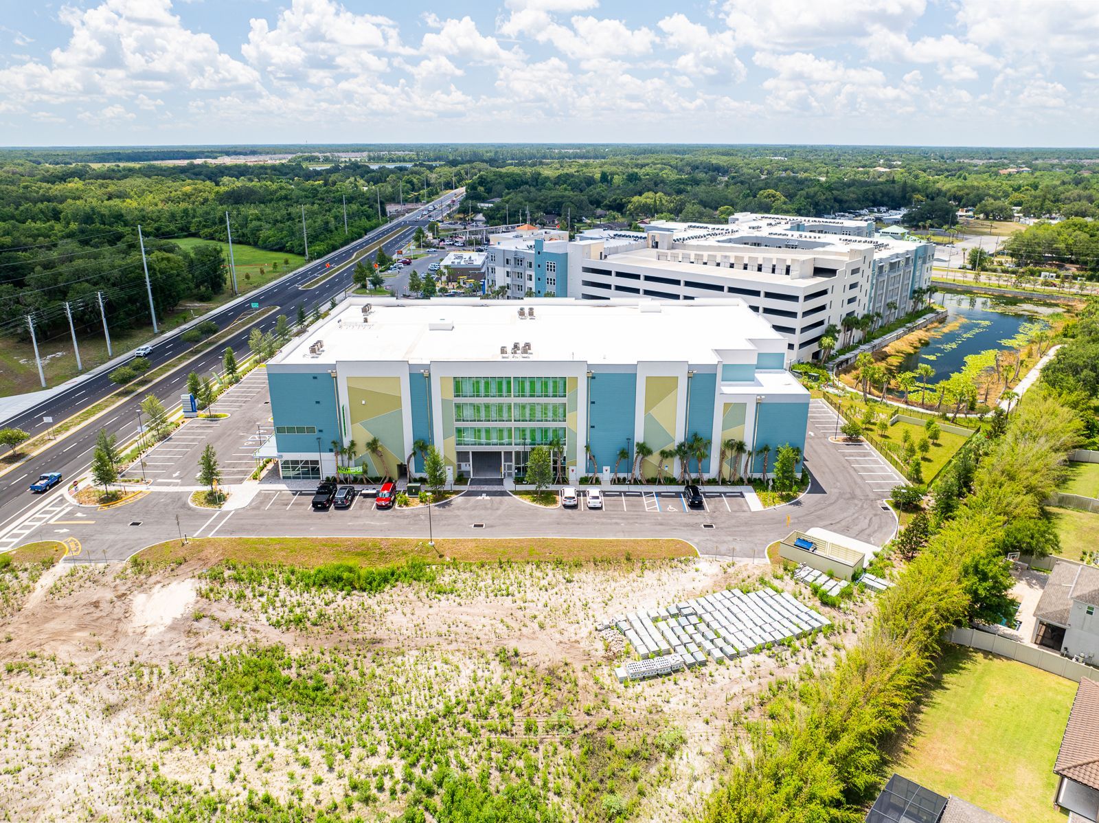 An aerial view of a large building surrounded by trees and a parking lot.