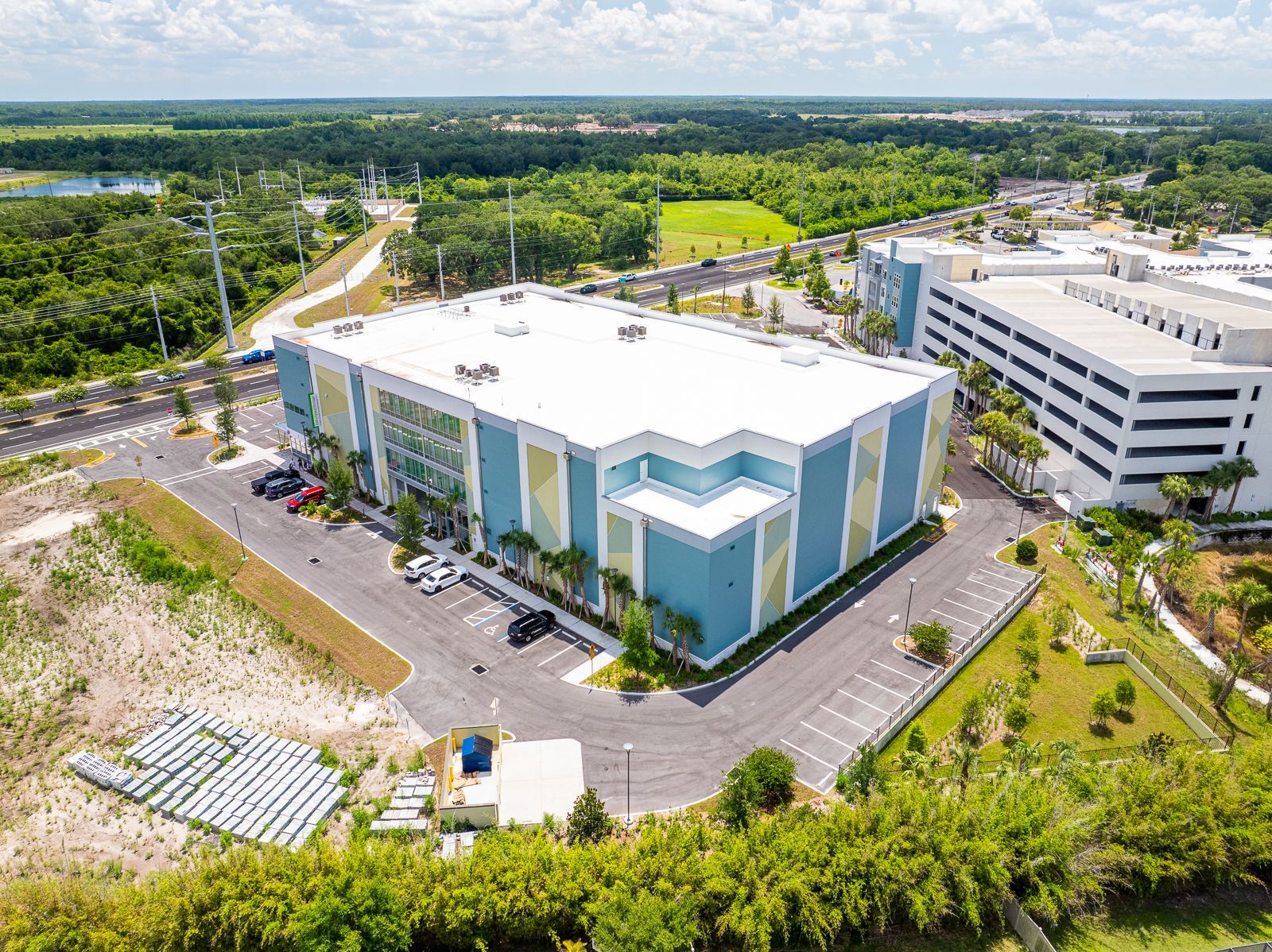 An aerial view of a large building surrounded by trees and a parking lot.