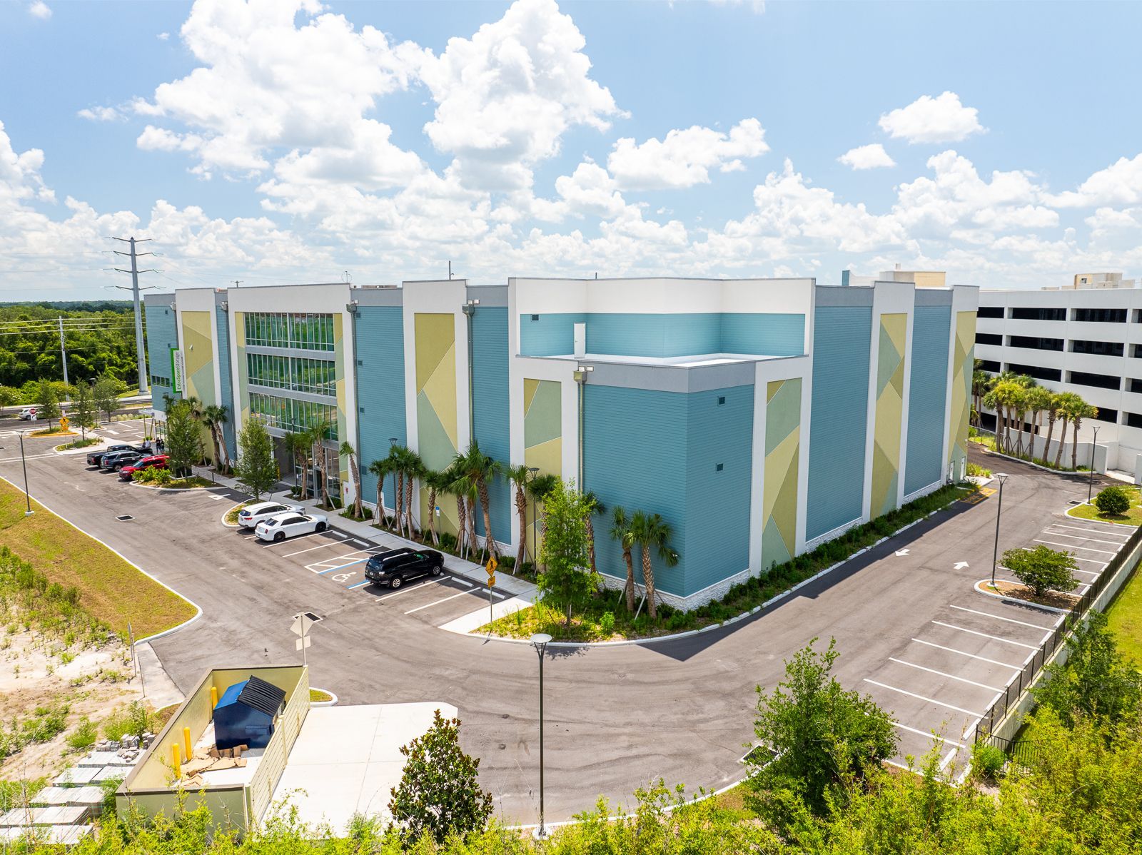 An aerial view of a large building with a parking lot in front of it.