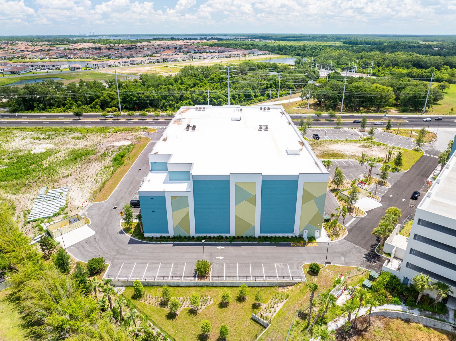 An aerial view of a large building surrounded by trees and a parking lot.