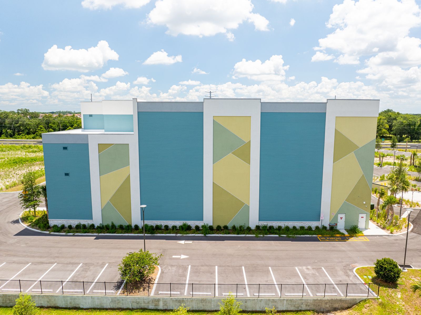 An aerial view of a large building with a parking lot in front of it.