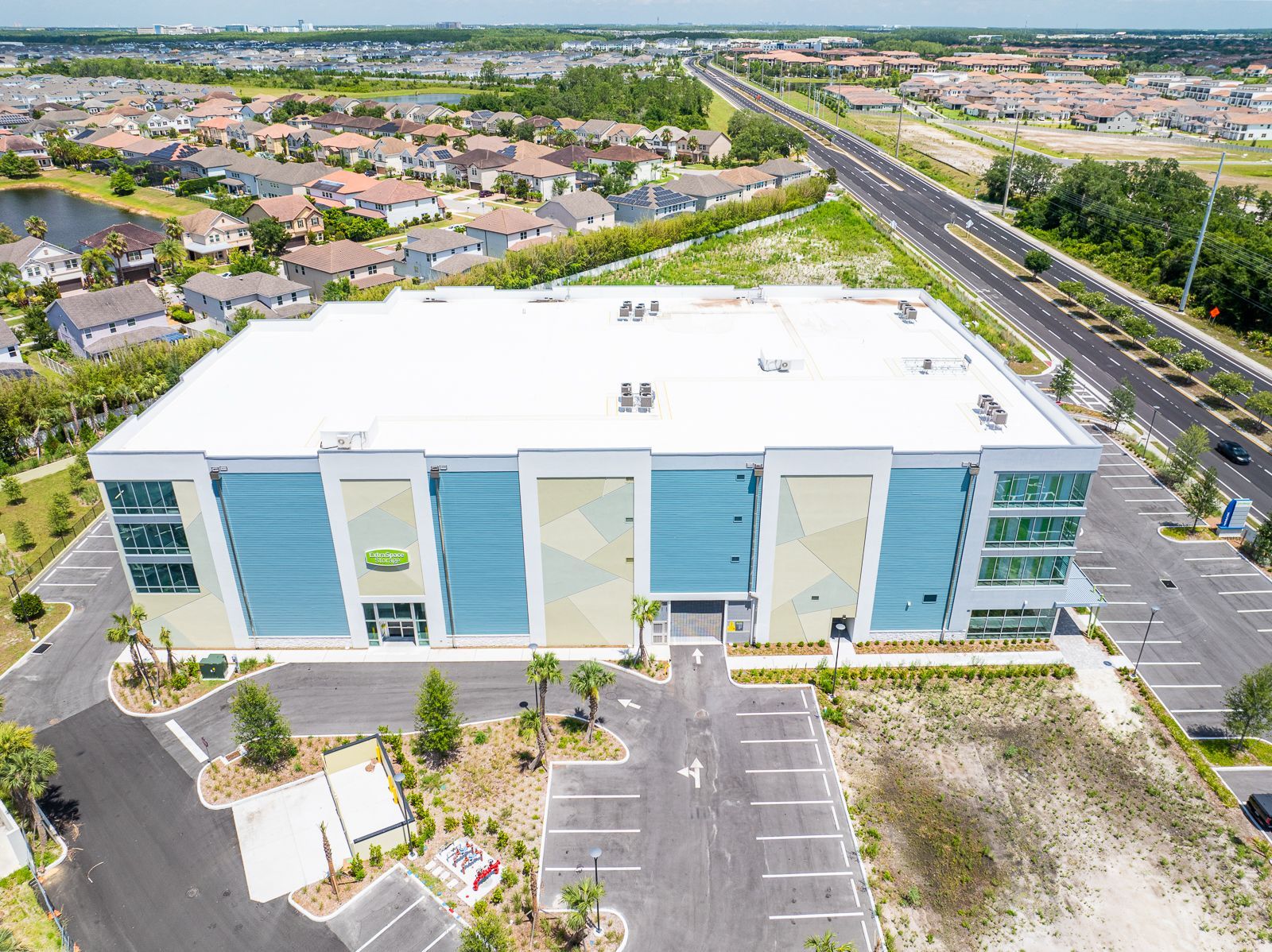 An aerial view of a large building with a parking lot in front of it.