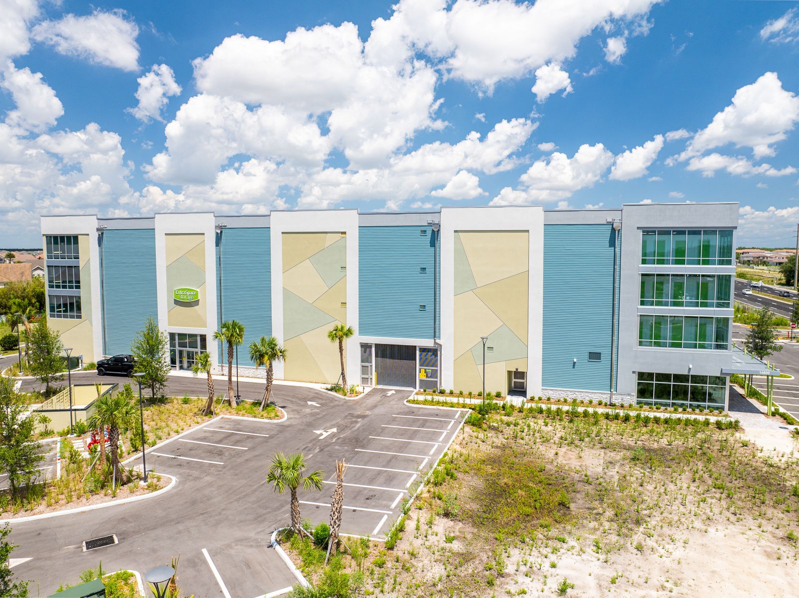 An aerial view of a large building with palm trees in front of it