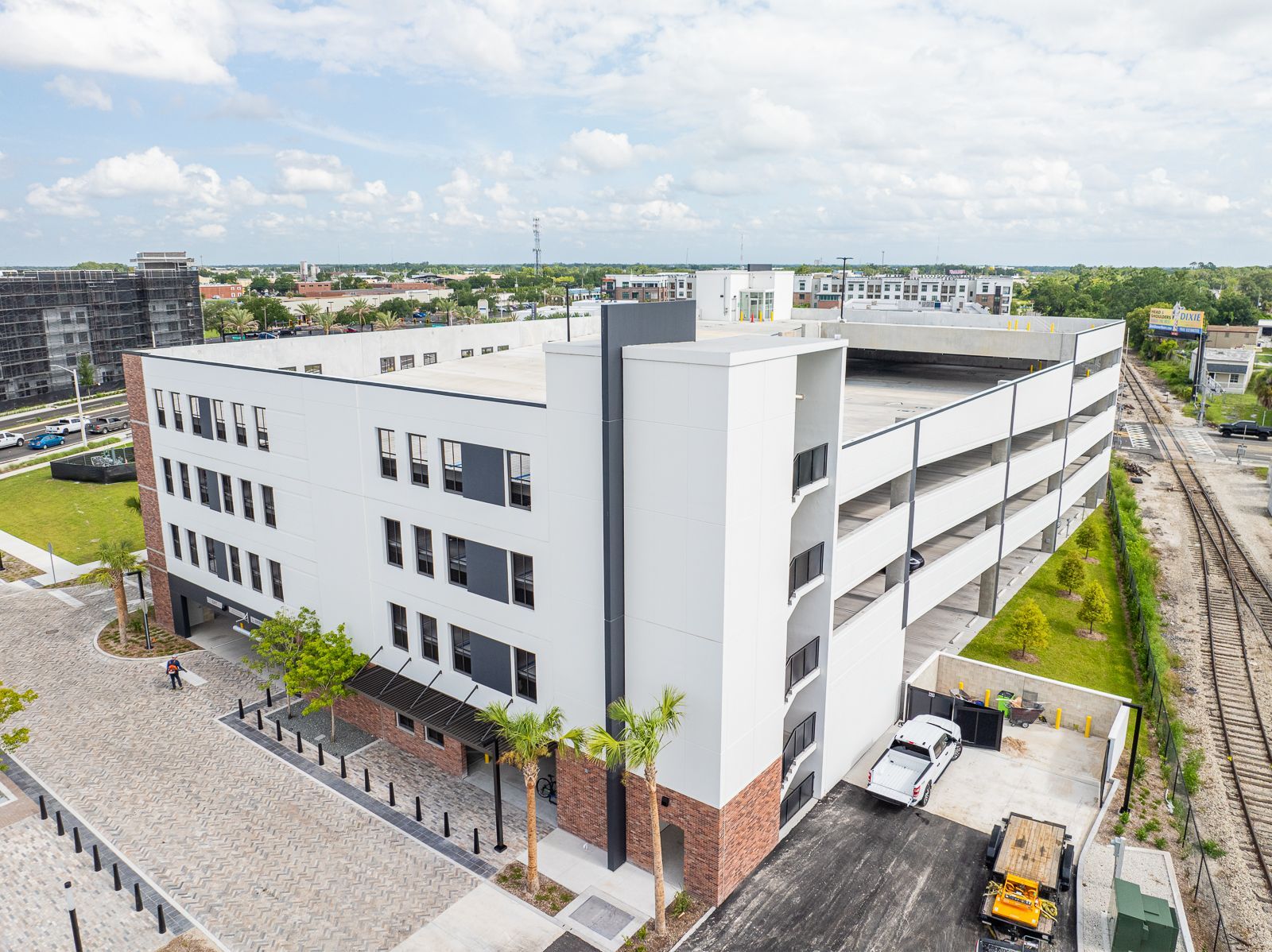 An aerial view of a large white building with a lot of parking spaces.