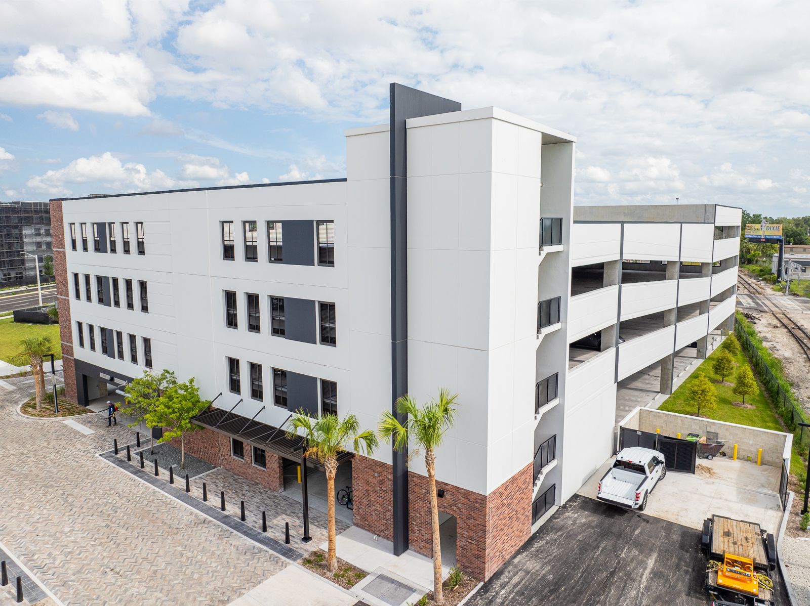 An aerial view of a large building with a parking garage in front of it.