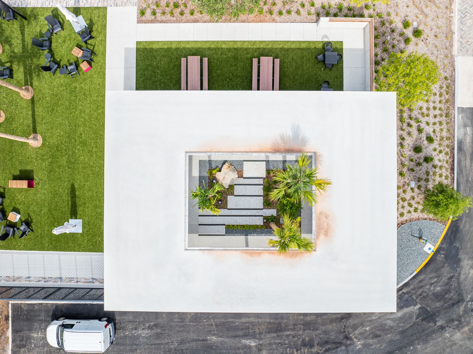 An aerial view of a park with a van parked in front of it.