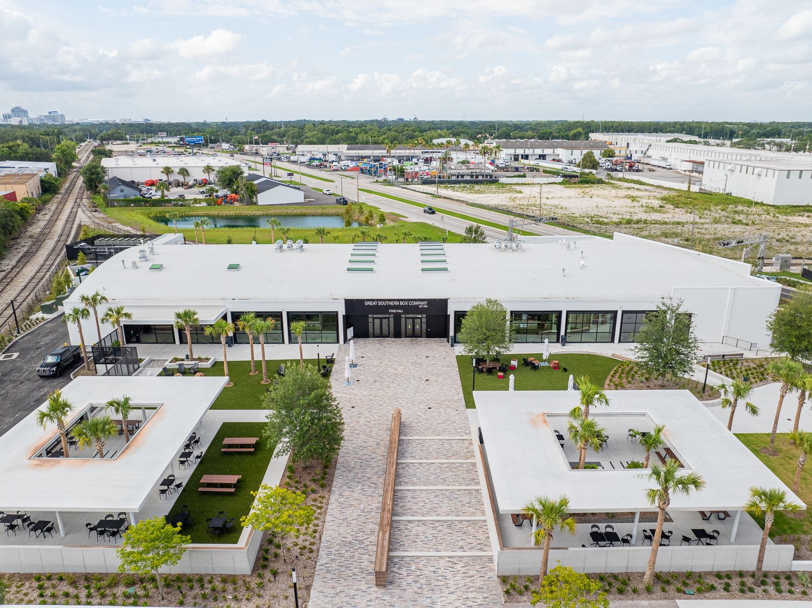 An aerial view of a large white building with palm trees in front of it.