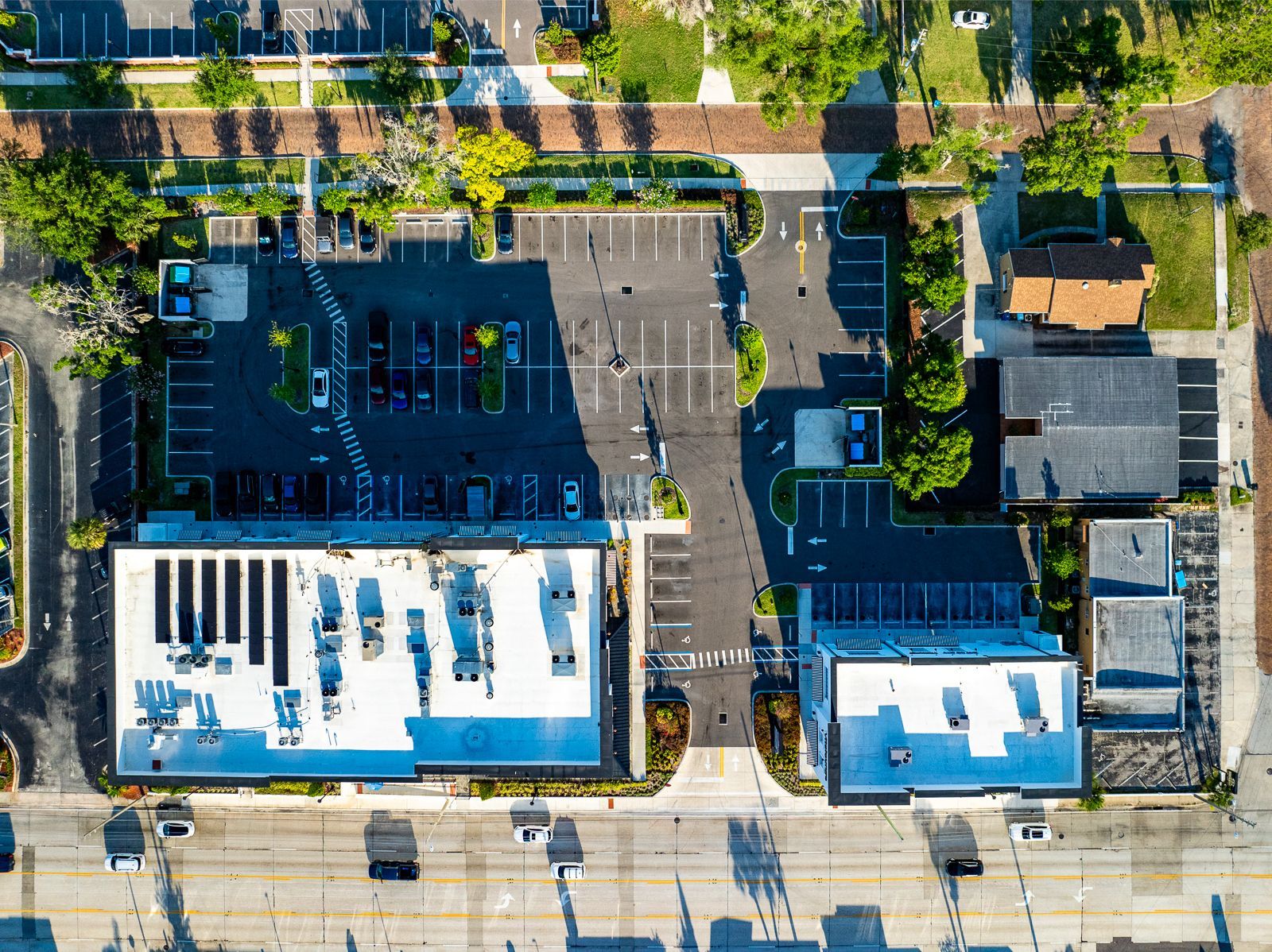 An aerial view of a parking lot and buildings in a city.
