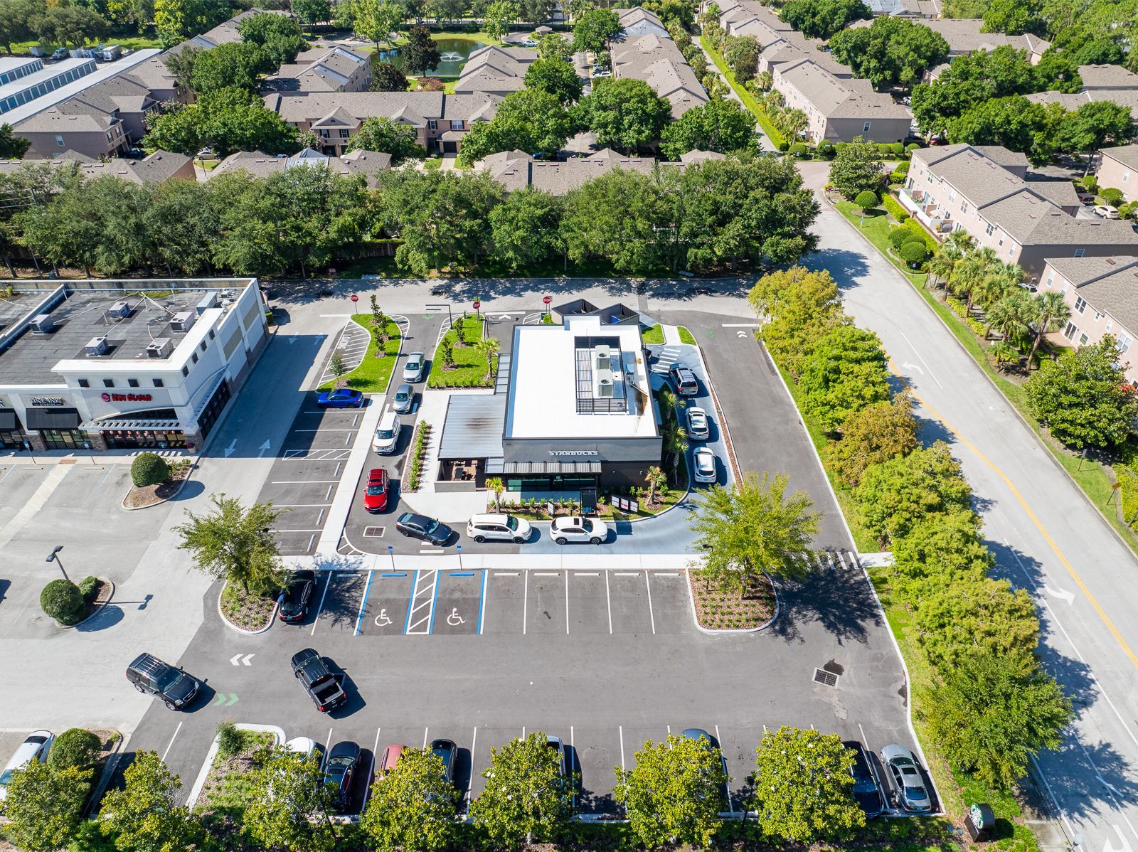 An aerial view of a parking lot and a building in a residential area.