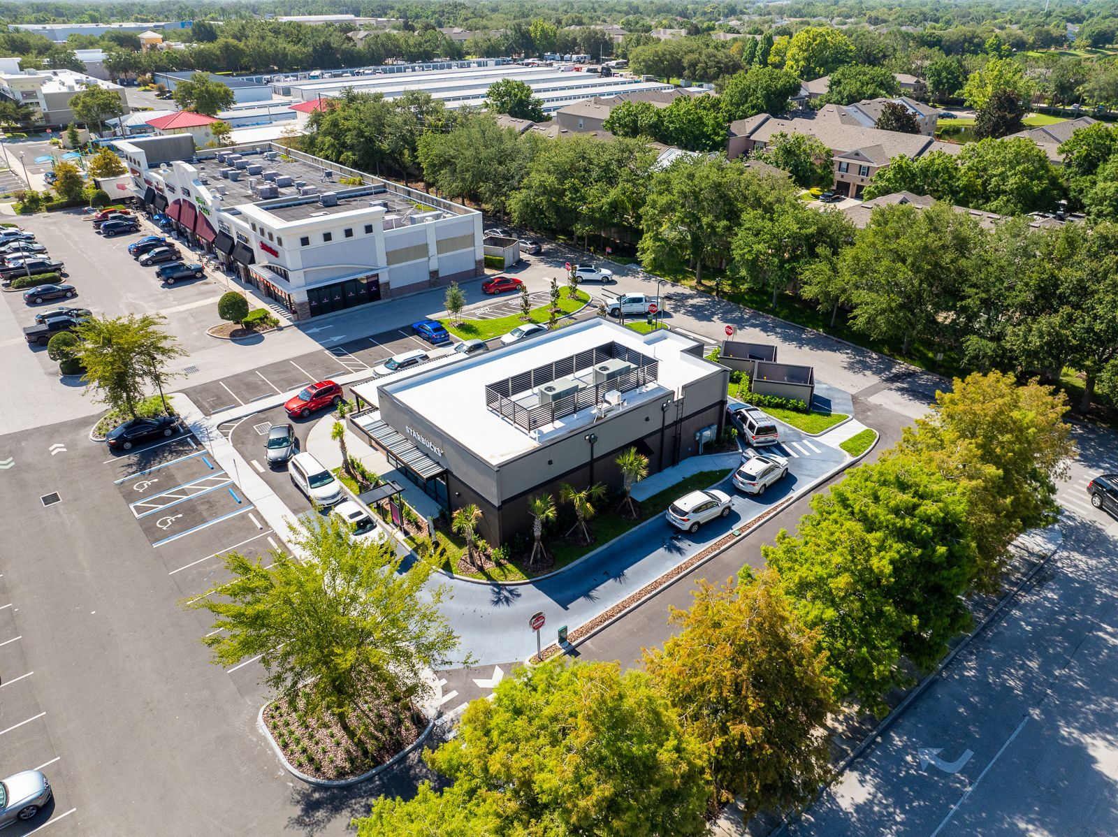 An aerial view of a building with a lot of cars parked in front of it.