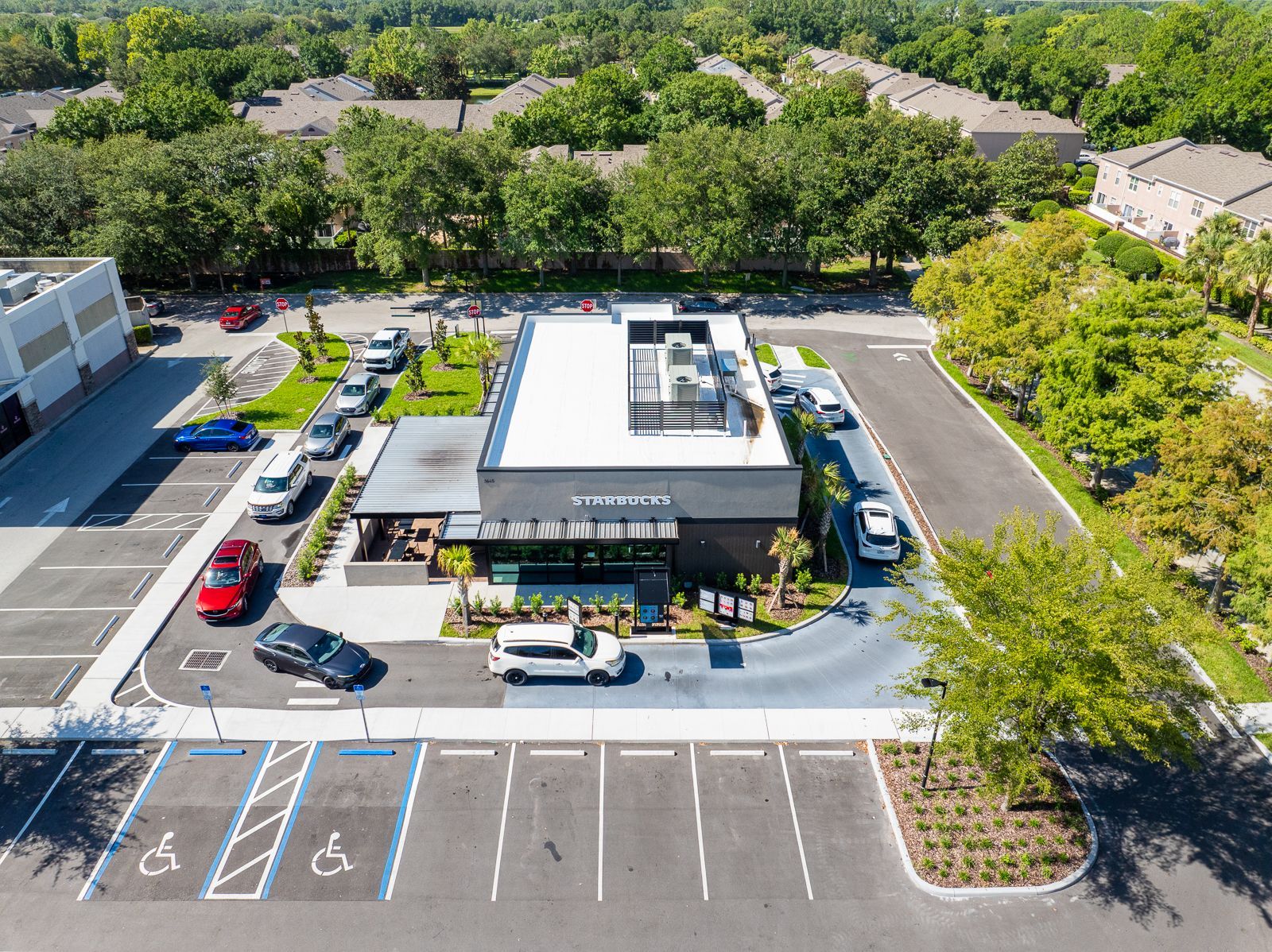 An aerial view of a parking lot with a building in the background.