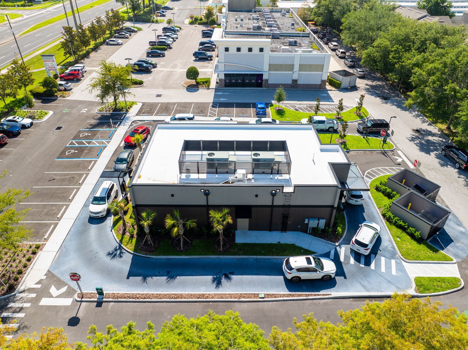 An aerial view of a fast food restaurant with cars parked in front of it.