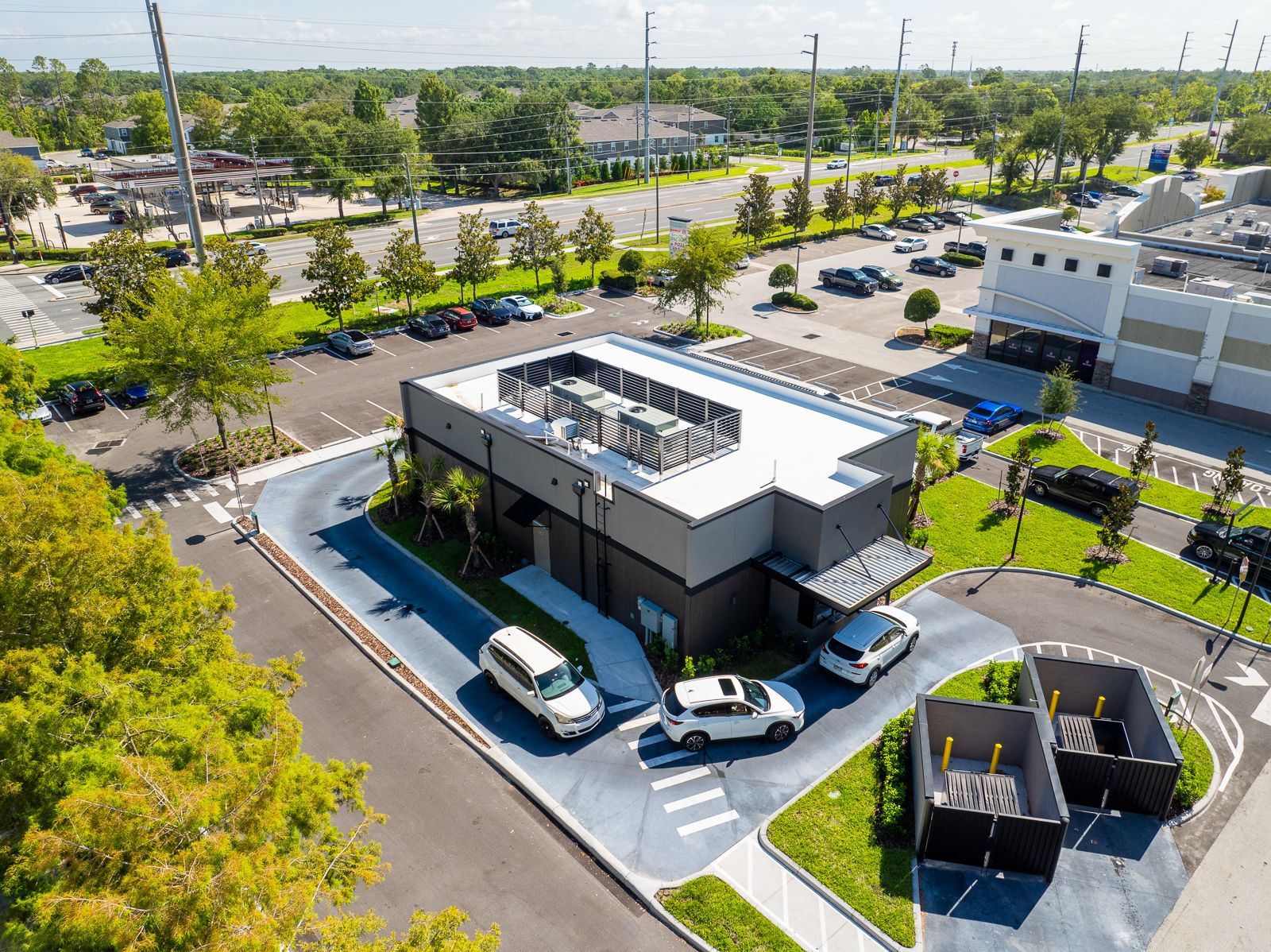 An aerial view of a fast food restaurant with cars parked in front of it.