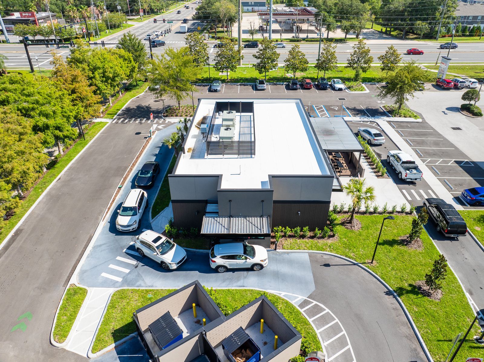 An aerial view of a fast food restaurant with cars parked in front of it.