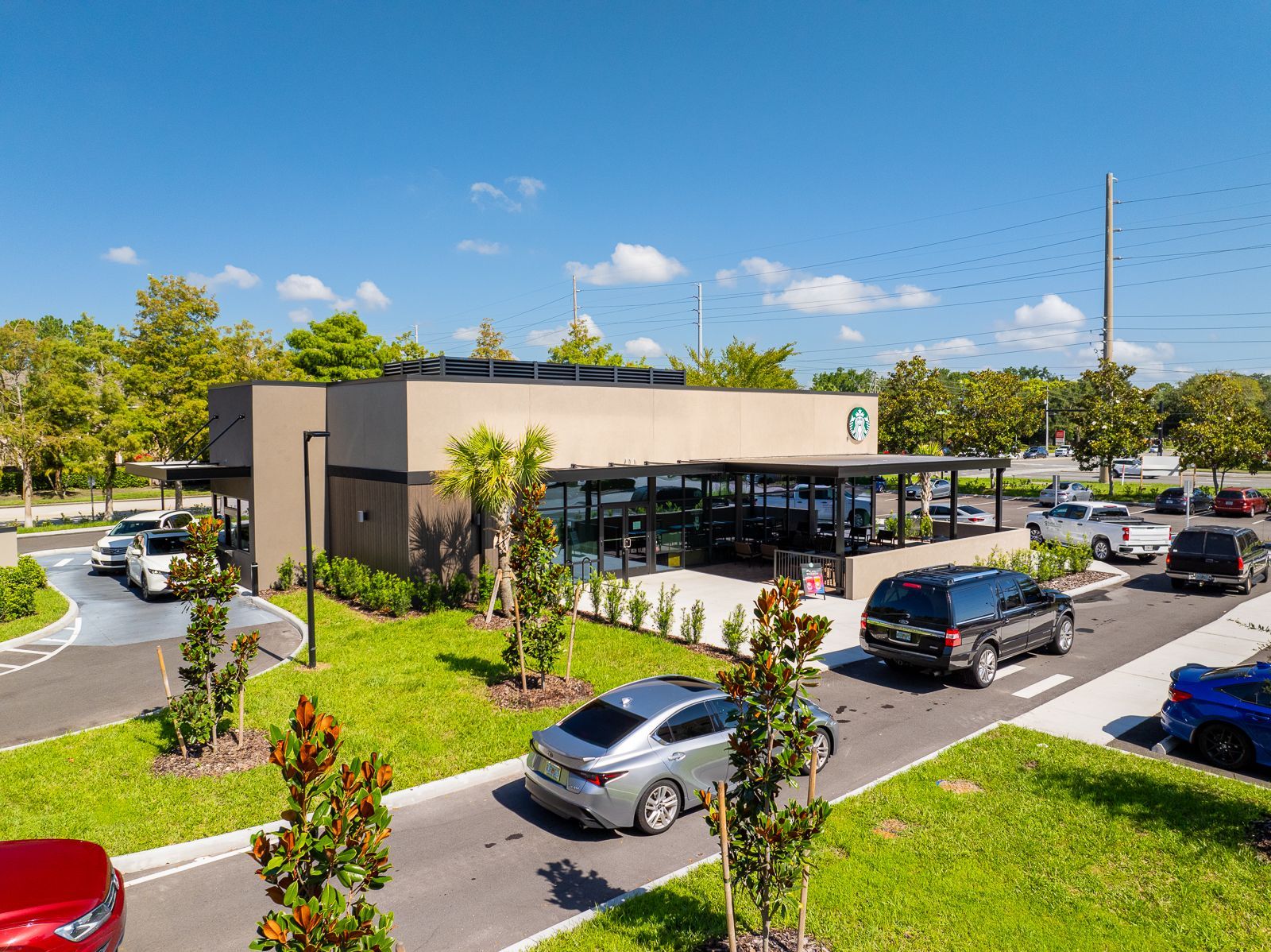 A row of cars are parked in front of a building.