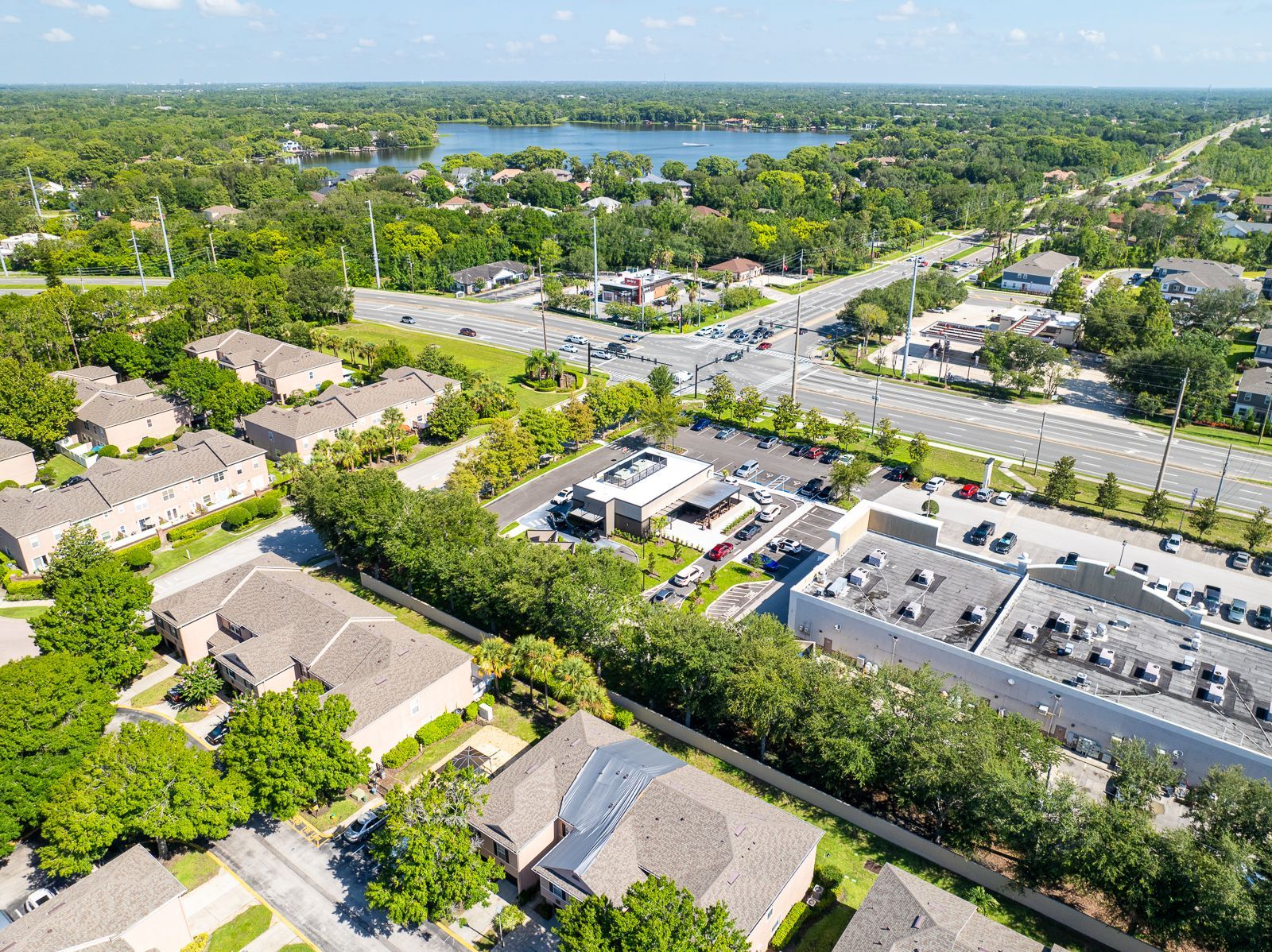 An aerial view of a residential area with a lake in the background.