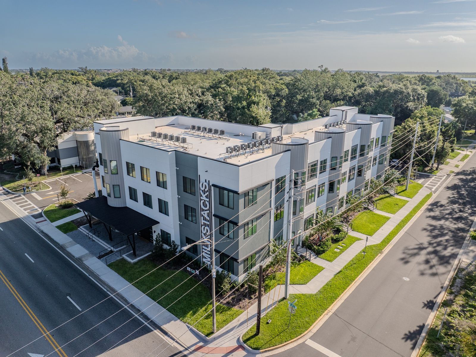Aerial view of a modern multi-story apartment building with gray and white exterior.