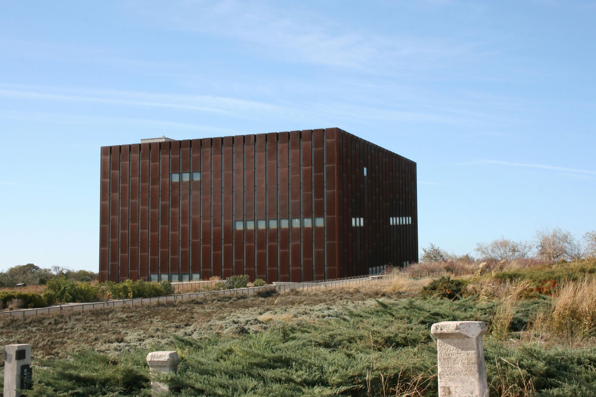 A large brick building built with low impact design practices with a blue sky in the background