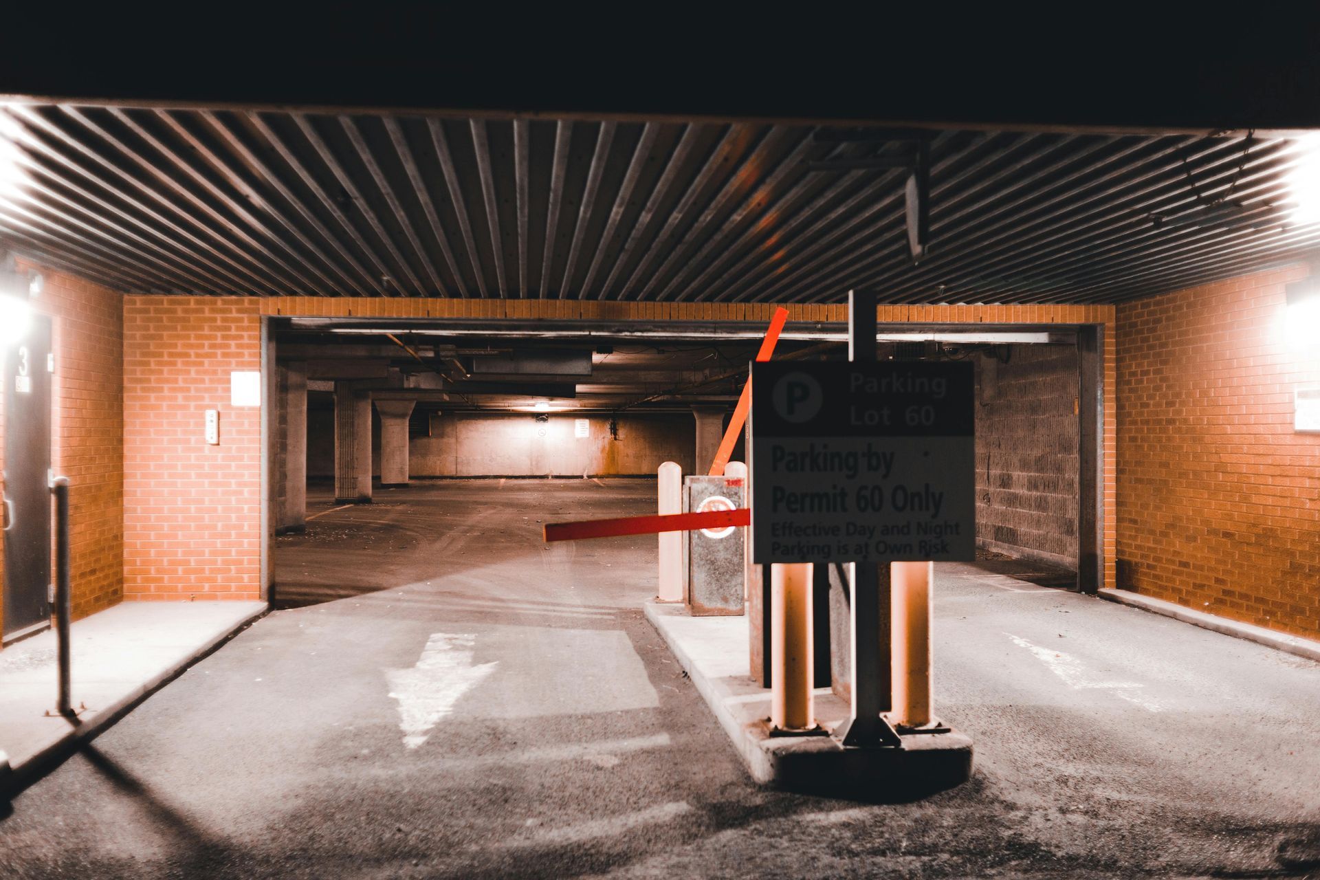 A parking garage with a red barrier and a sign that says parking only.