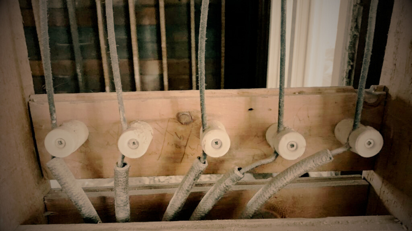 Antique knob and tube electrical wiring visible within an open wall structure.