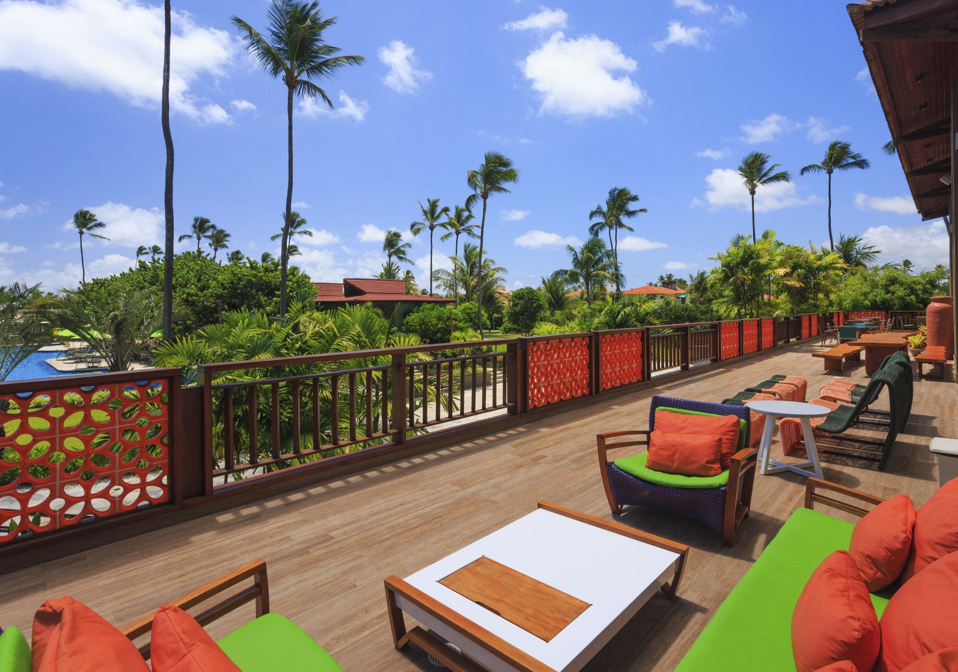 Uma varanda com mesa e cadeiras e palmeiras ao fundo