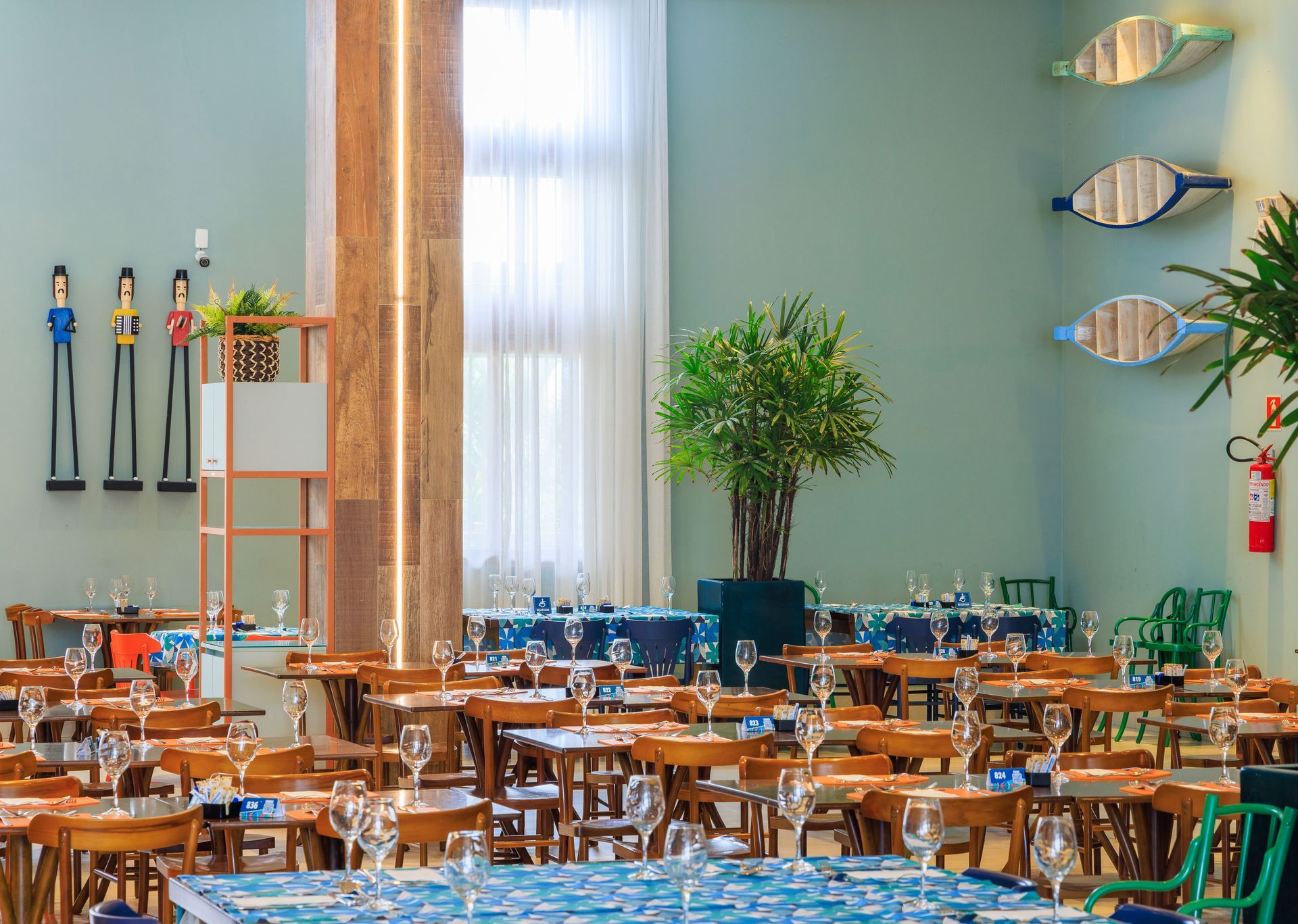 Um restaurante cheio de mesas, cadeiras e taças de vinho.