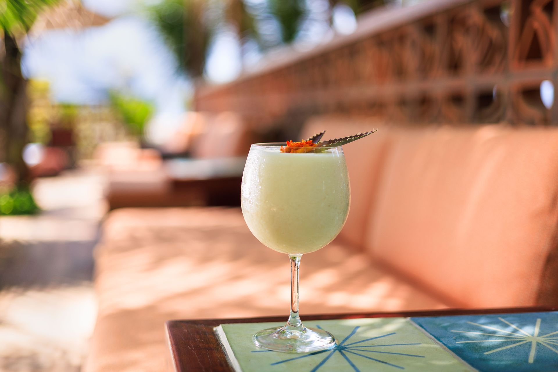 Um close de uma bebida em uma taça de vinho sobre uma mesa.