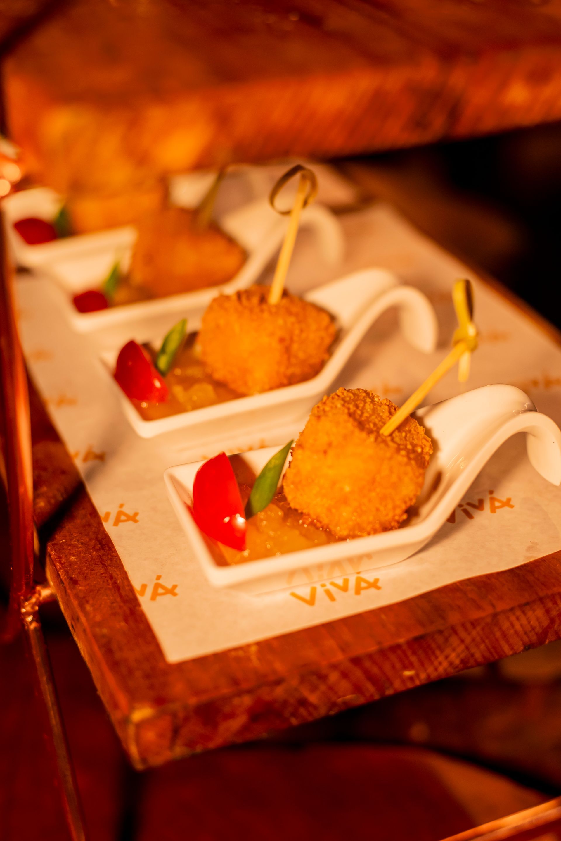 Uma mesa de madeira coberta com uma bandeja de comida em colheres.