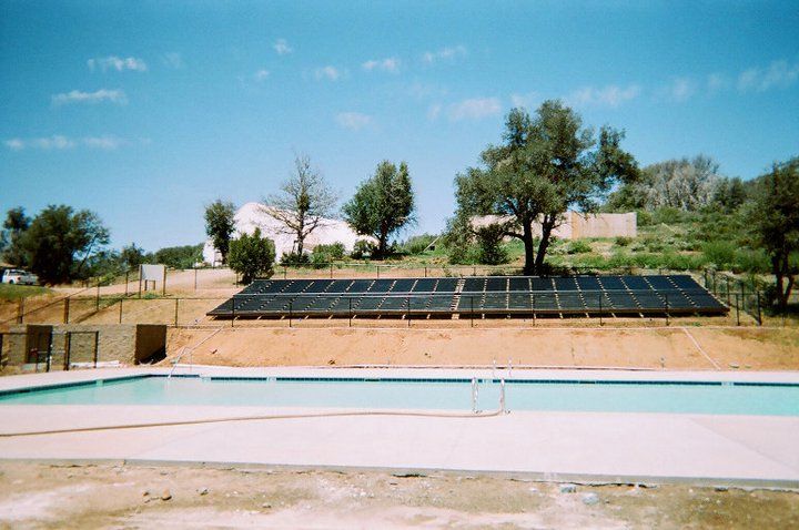 Swimming pool with solar panels on the side of it — San Diego, CA — Mark Naylor Solar Specialists