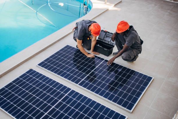 Two contractors are installing the solar panel for the pool solar system.