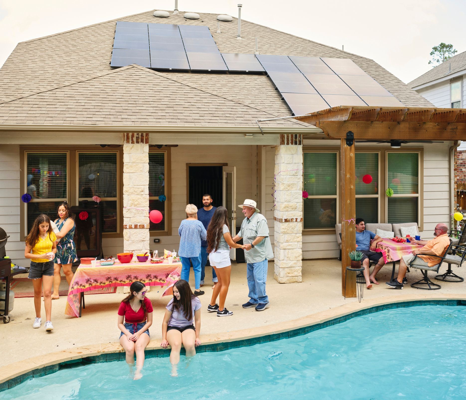 A family backyard pool party with a pool solar system. A family backyard pool party with a pool solar system.