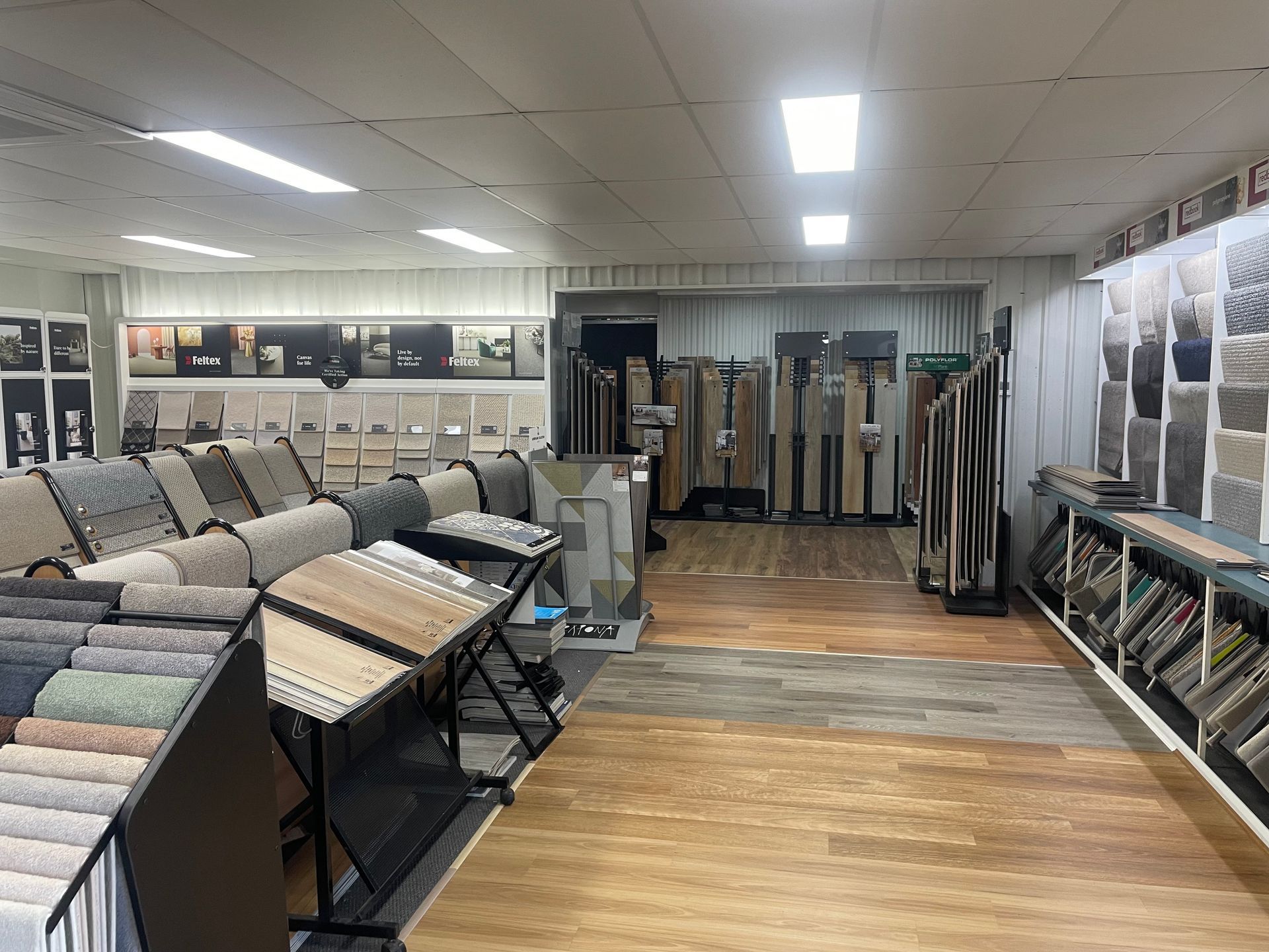Interior of a flooring store displays carpet and tile samples, wood flooring.