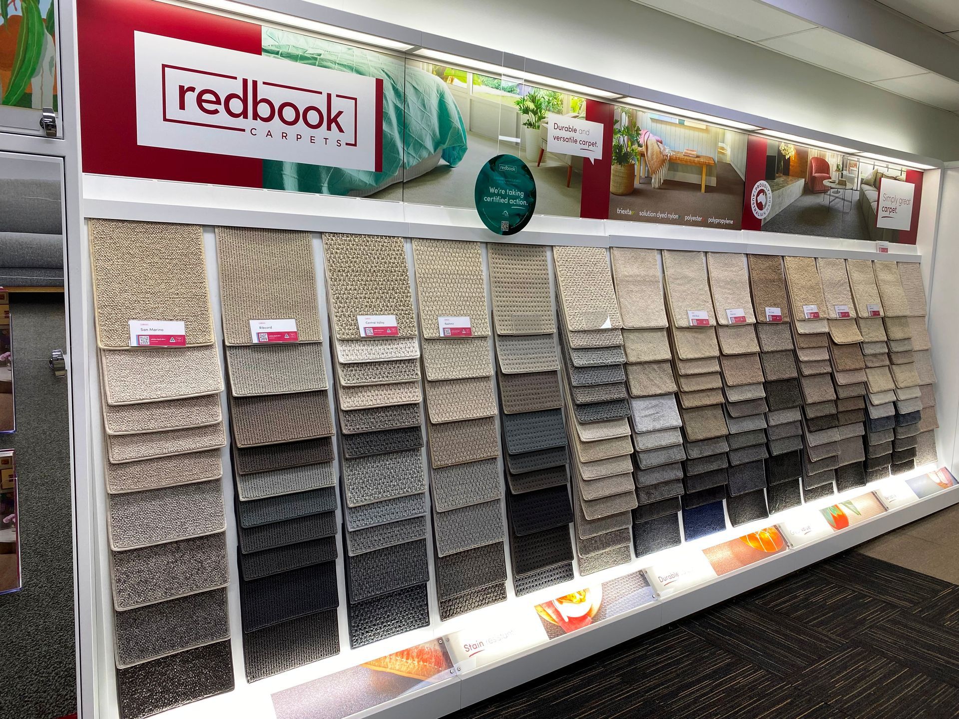 Display of carpet samples in varying shades of gray and beige, with 
