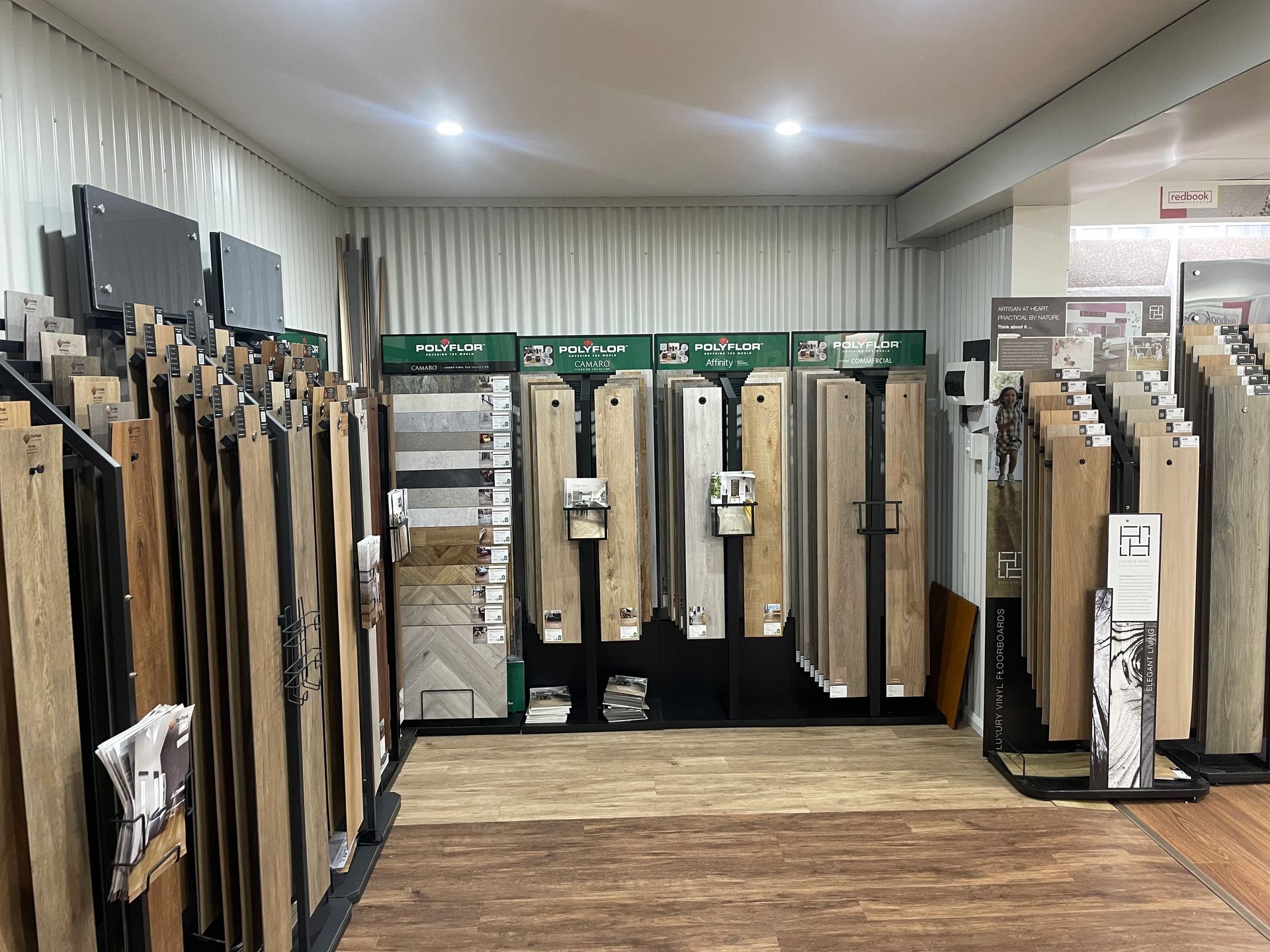 Flooring samples displayed in a retail store, showcasing various wood and tile styles.