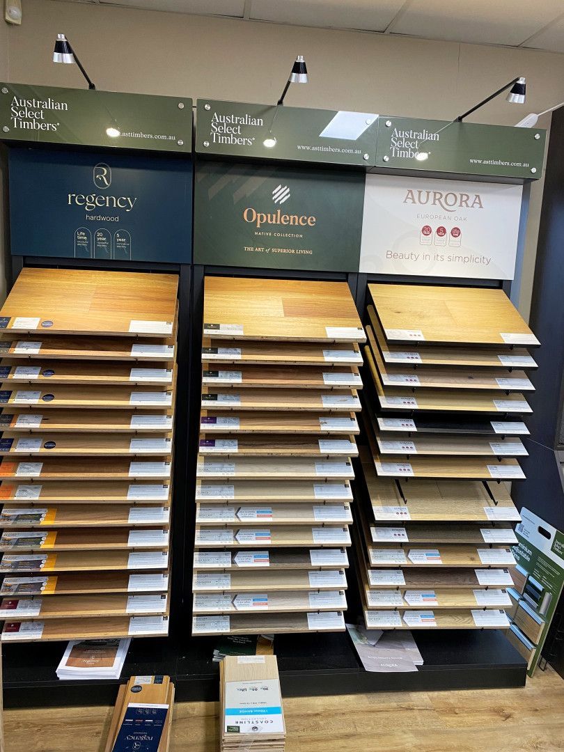 Display of various wood flooring samples on shelves.