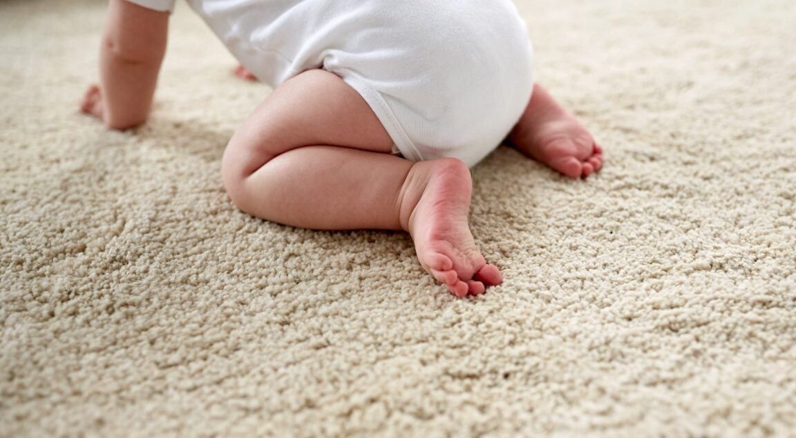 Baby Crawling on A Beige Carpet, Wearing a White Onesie — Gava Floor Centre in Alstonville, NSW