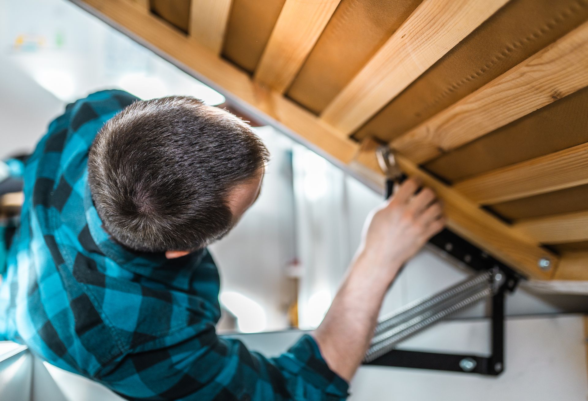 A mover disassembling a bedlift mechanism using a furniture spanner.