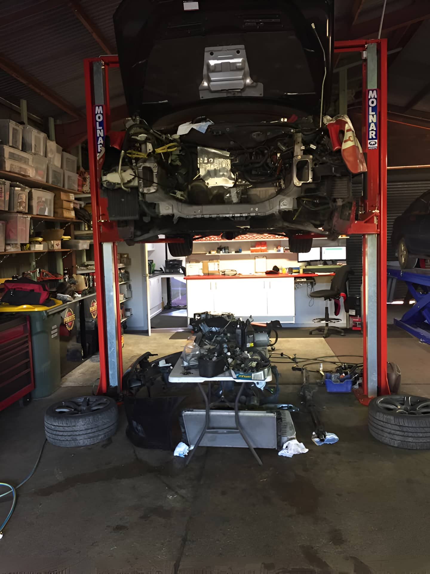 A Car Is Sitting On A Lift In A Garage — Cannon Automotive Services In East Maitland, NSW
